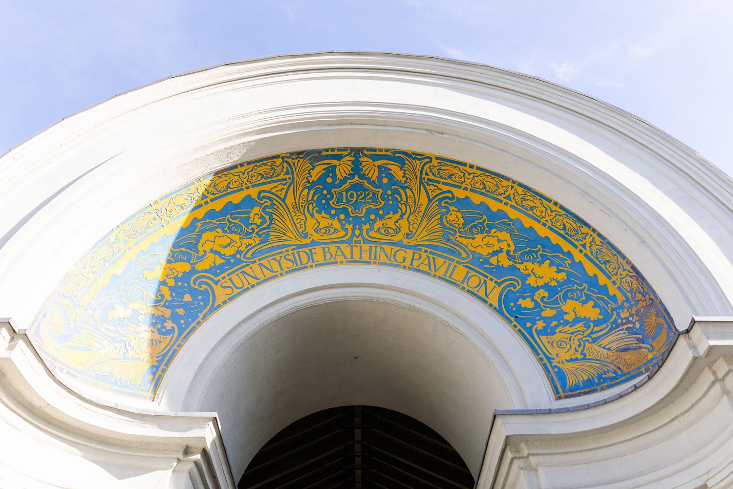 Ornate gold and blue mosaic pattern decorates an arched architectural detail.