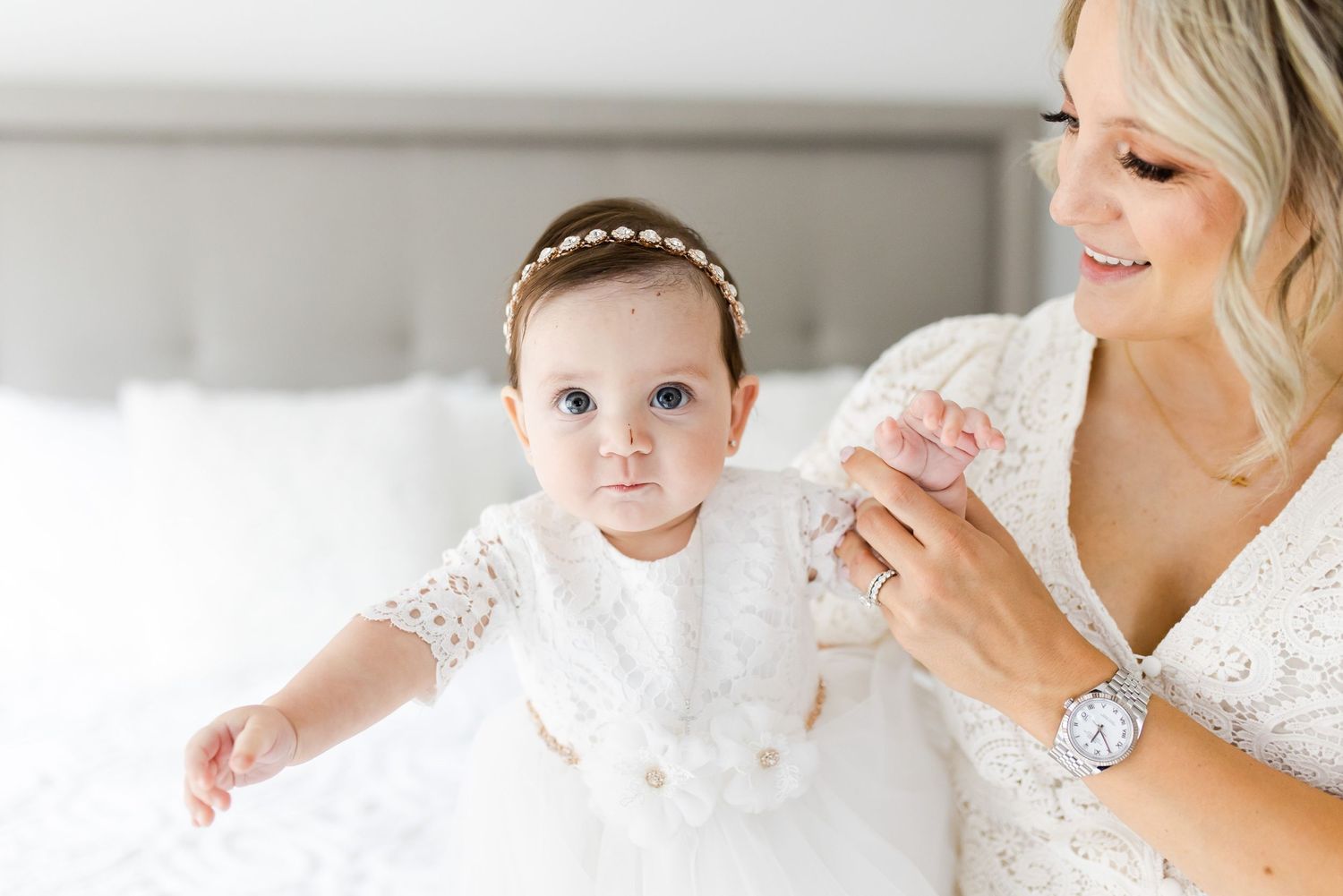 Baby in traditional white baptism dress with beaded headband.