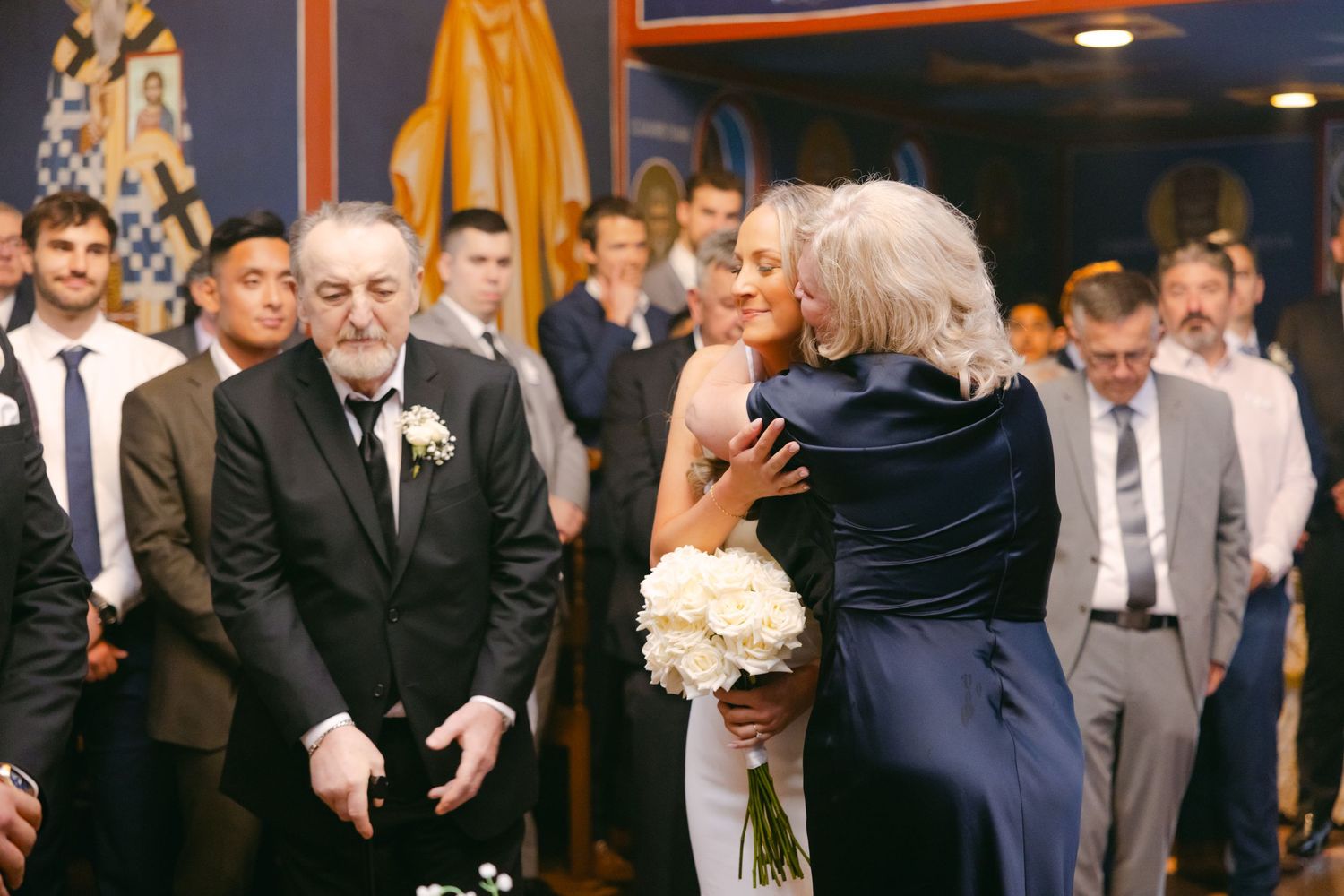Emotional moment during wedding ceremony in front of religious iconography.
