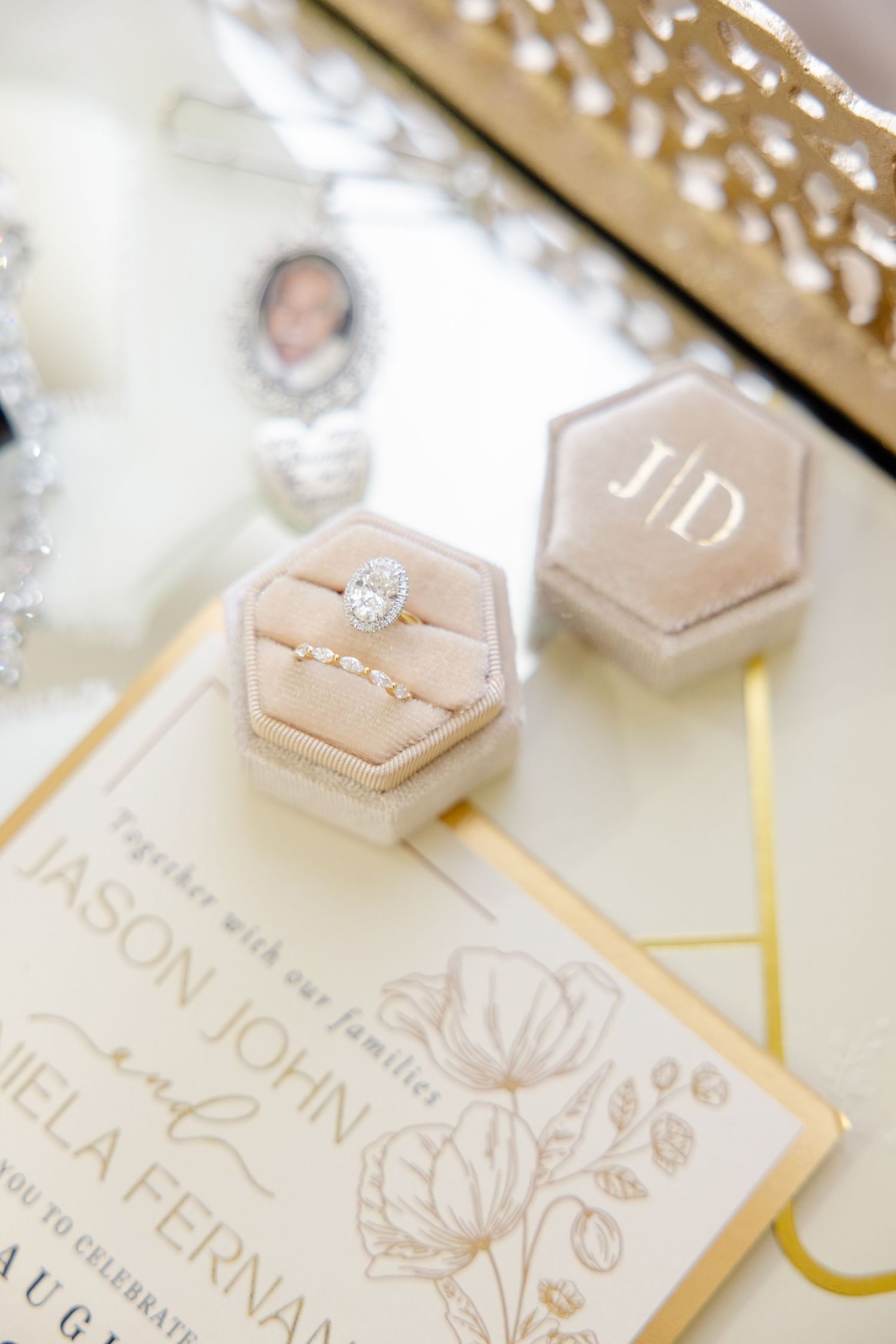 Wedding invitation suite with hexagonal ring box and gold accents on white surface.