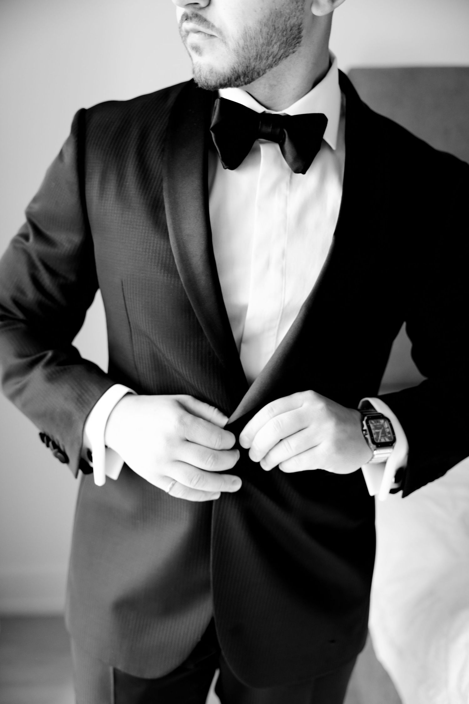 Close-up black and white photo of tuxedo details including bow tie and lapels.