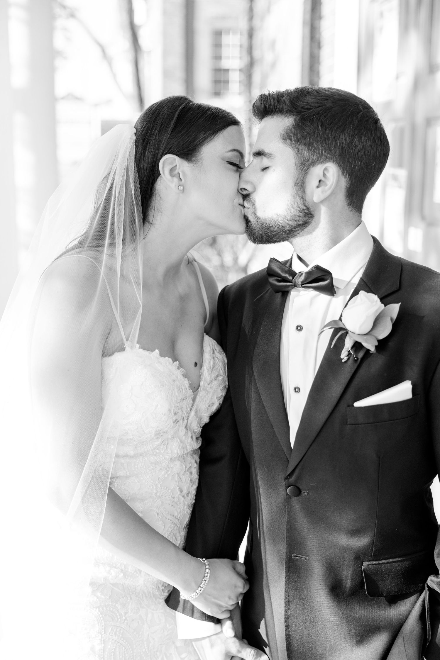 Black and white romantic wedding portrait capturing an intimate moment between newlyweds.