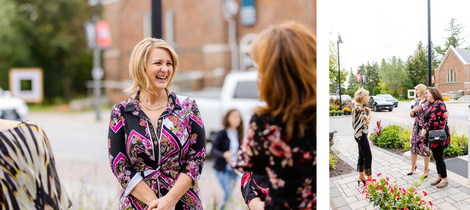 Joyful interaction between two people wearing floral dresses during an outdoor event.