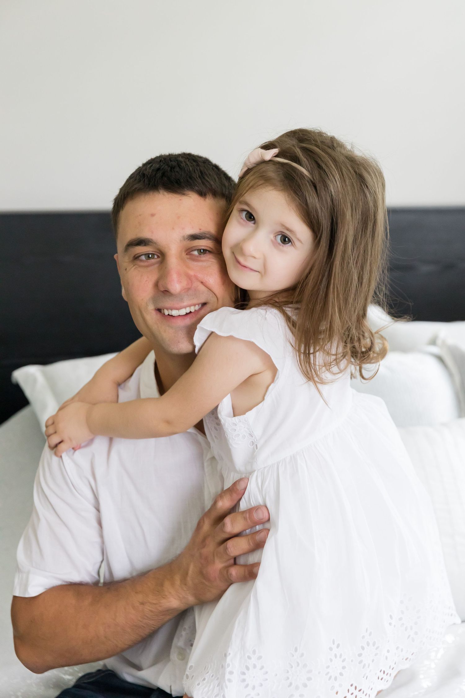 Sweet family moment captured with parent and child hugging on bed.