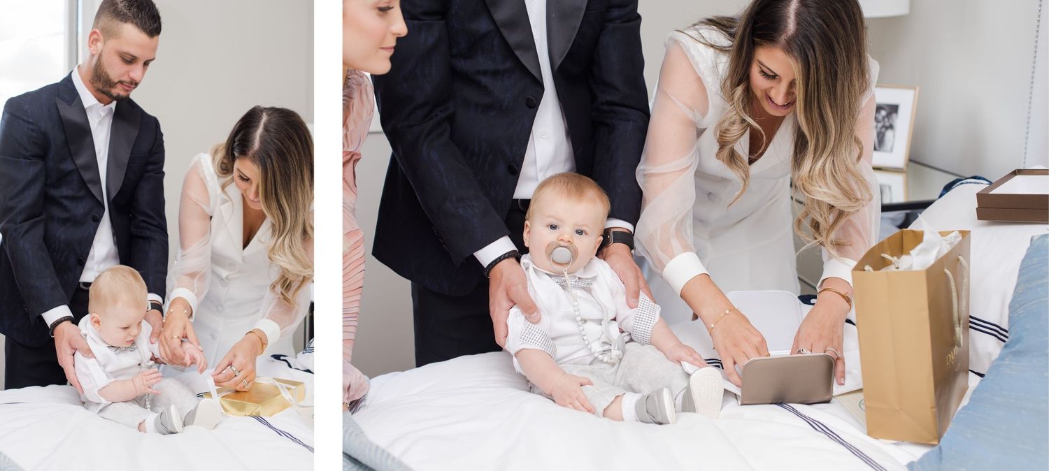 Group examining documents and celebrating with baby in bright modern room.