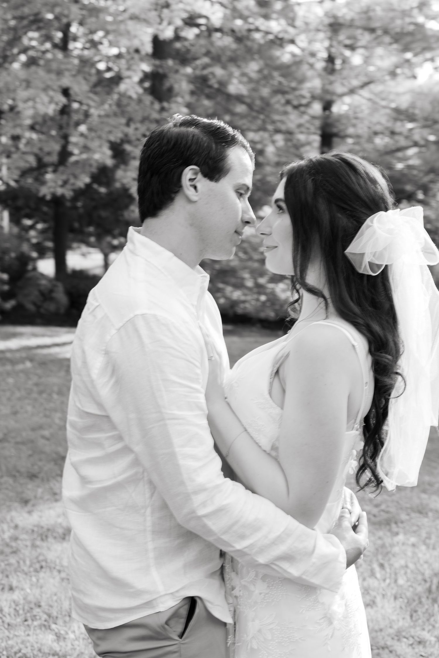 An intimate black and white portrait of a couple in wedding attire.