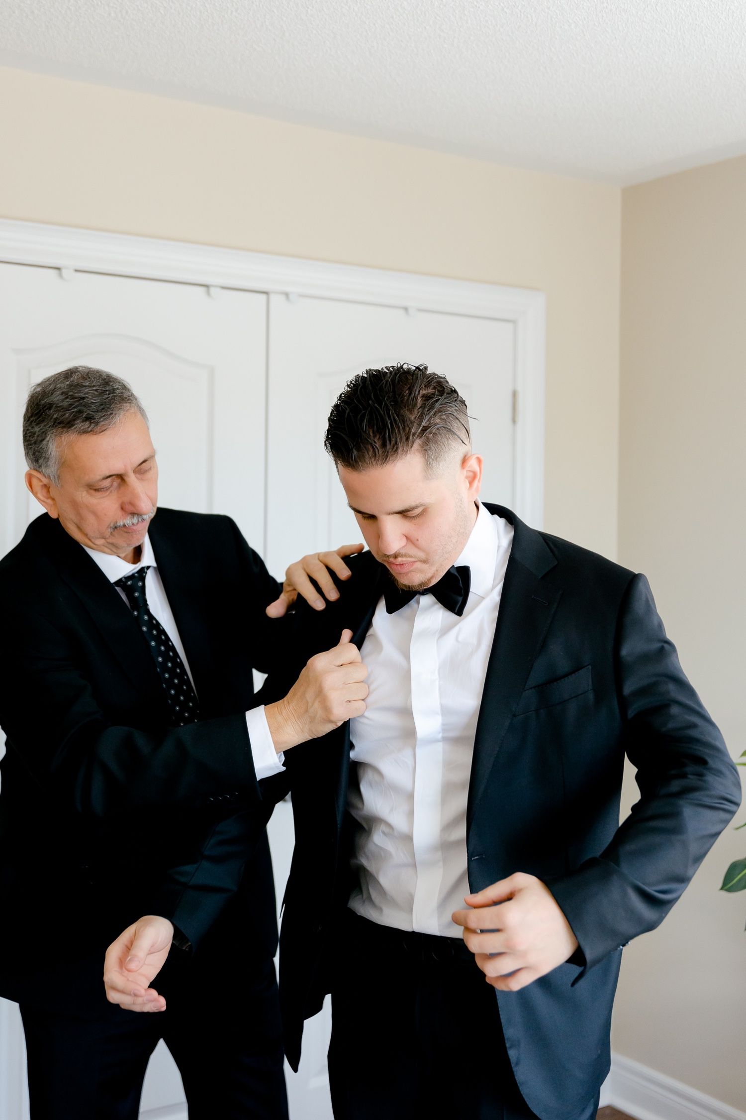 Final touches being made to formal attire during wedding preparations.