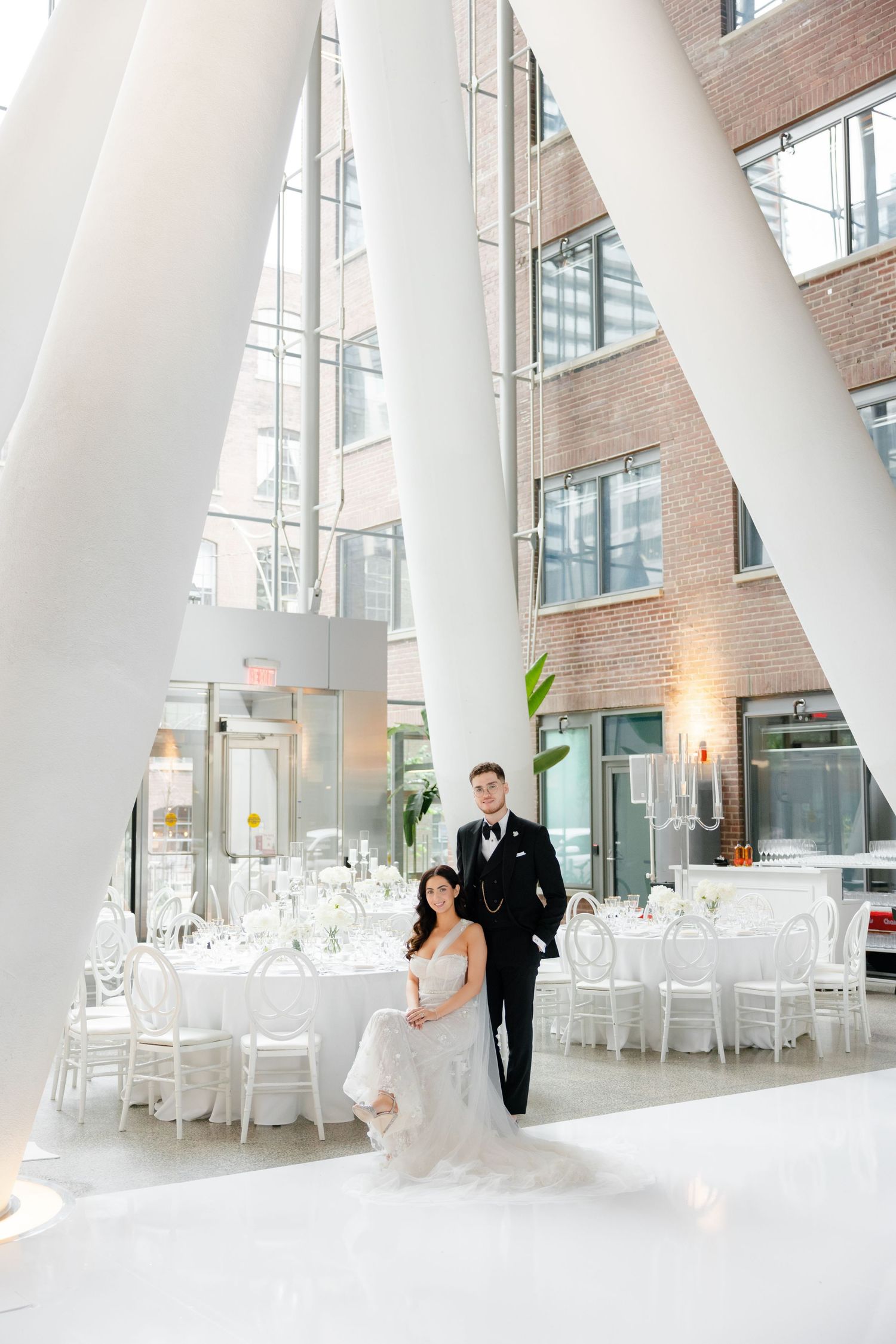 Modern architectural venue with dramatic white columns and elegant wedding reception setup.