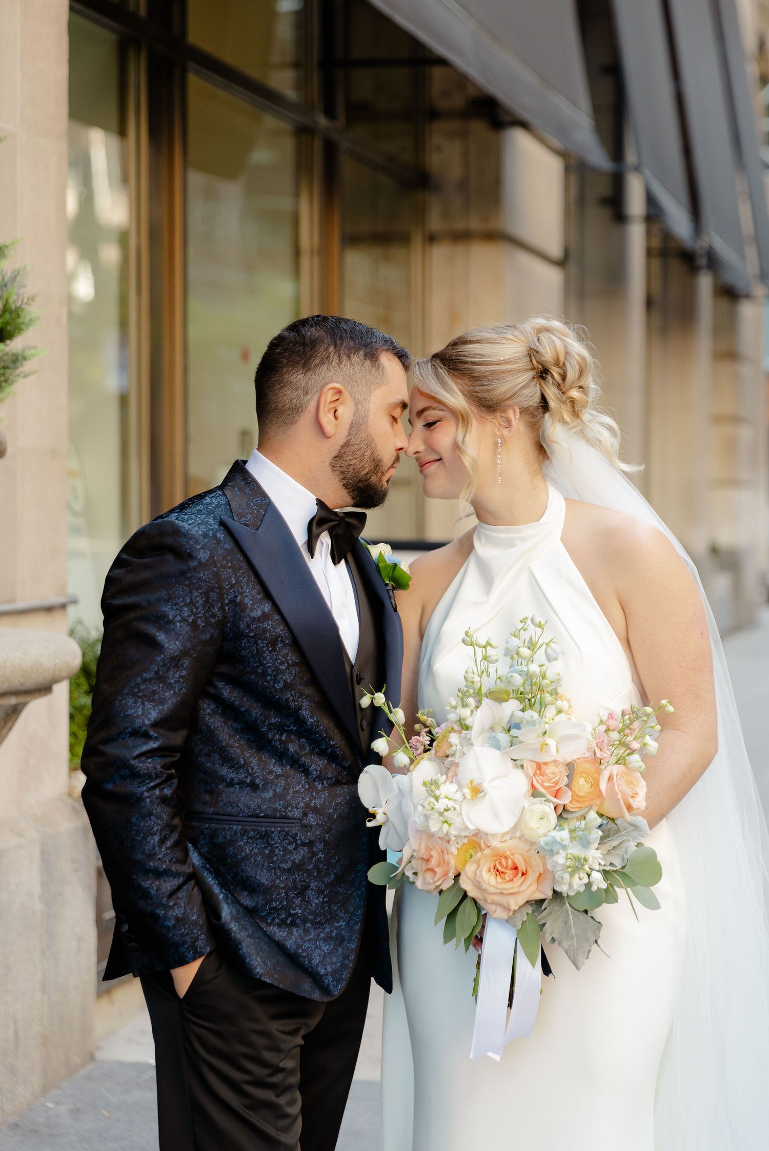 Wedding couple shares intimate moments in a series of romantic outdoor portraits against stone architecture.