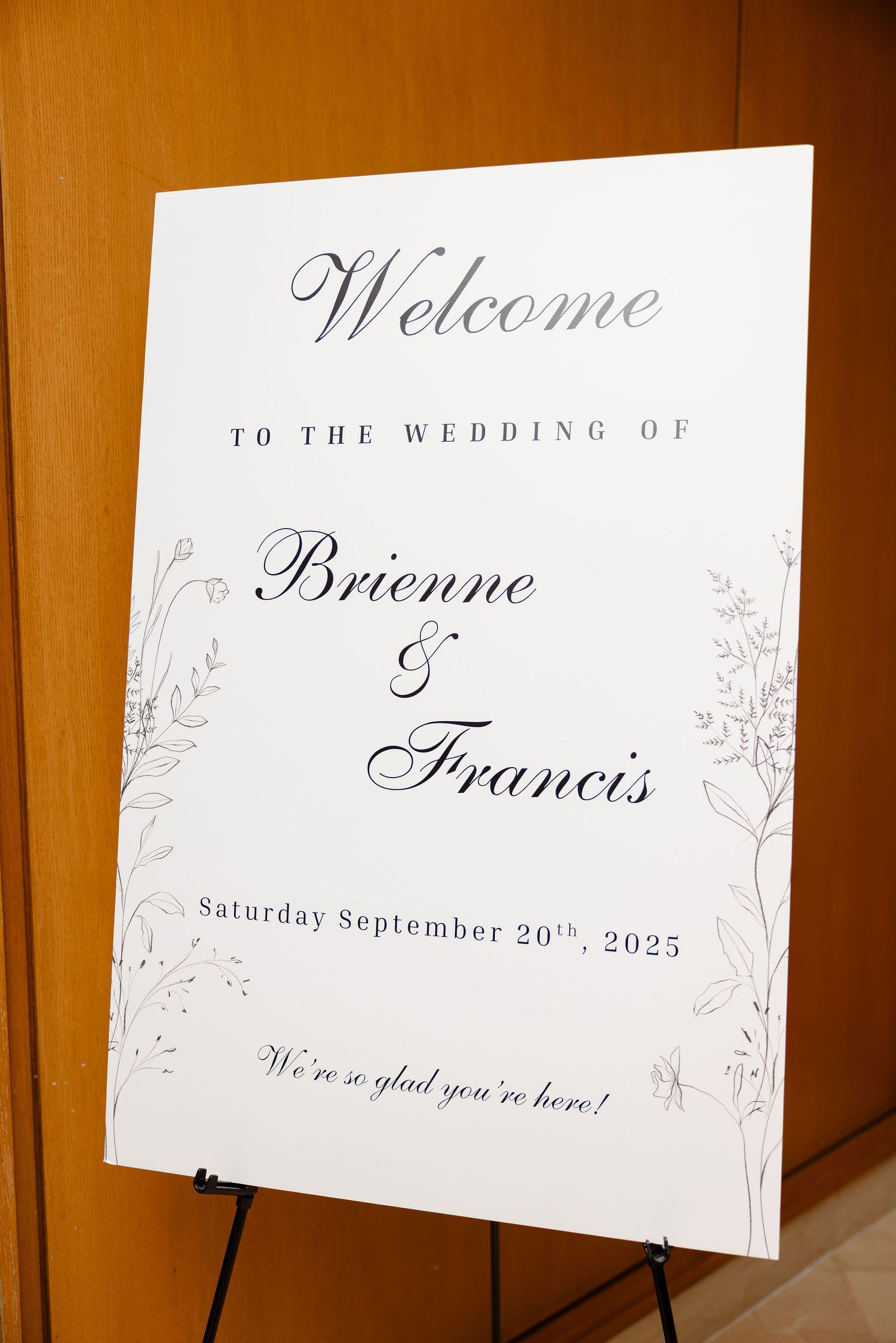 Wedding welcome signs with elegant calligraphy displayed on wooden stands.
