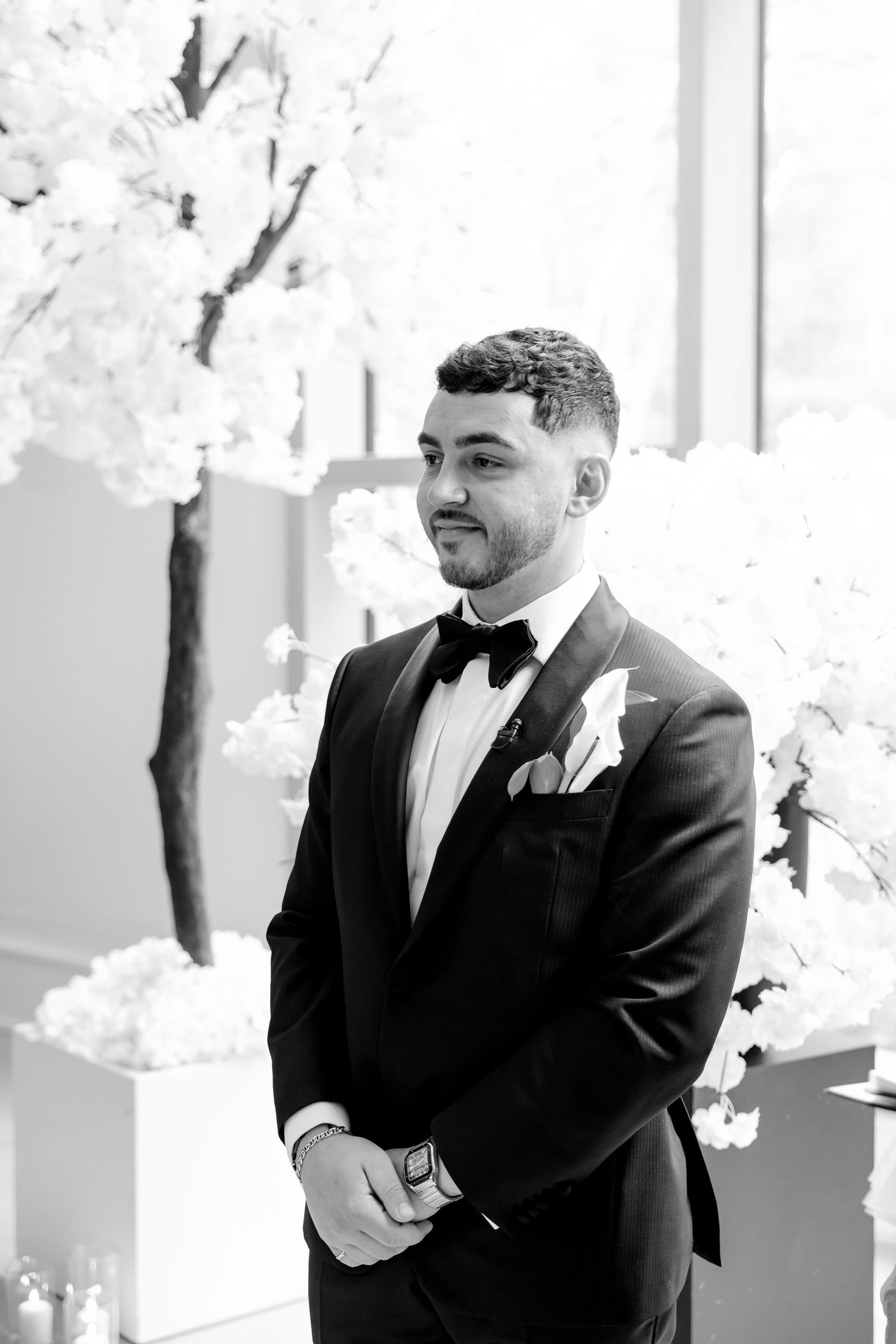 Black and white portrait in formal attire during wedding ceremony.