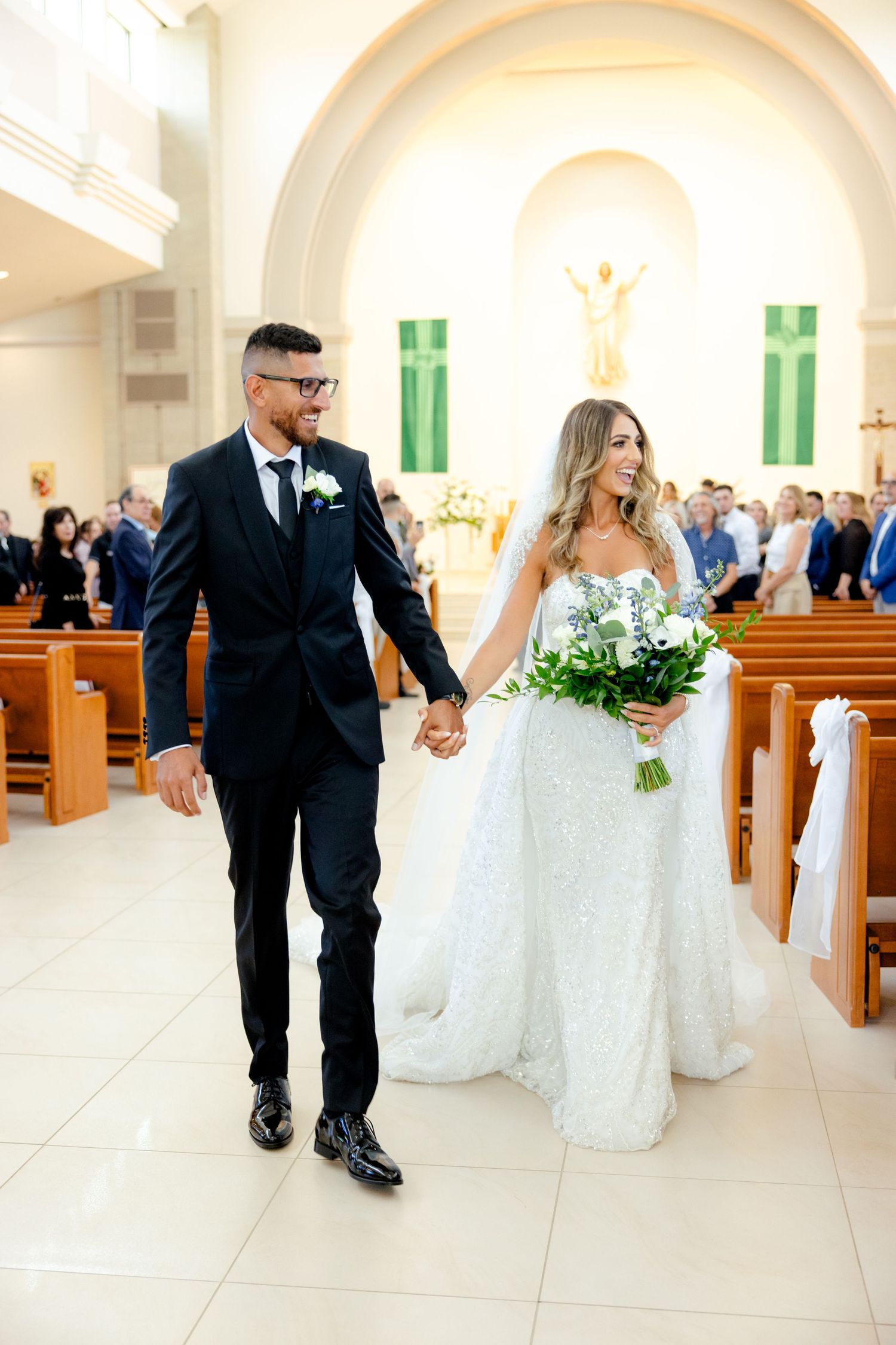 Elegant recessional through church with classic white and cream decor.