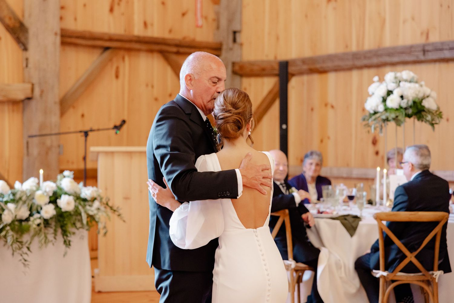 A romantic dance moment captured in a beautifully decorated rustic barn wedding venue.