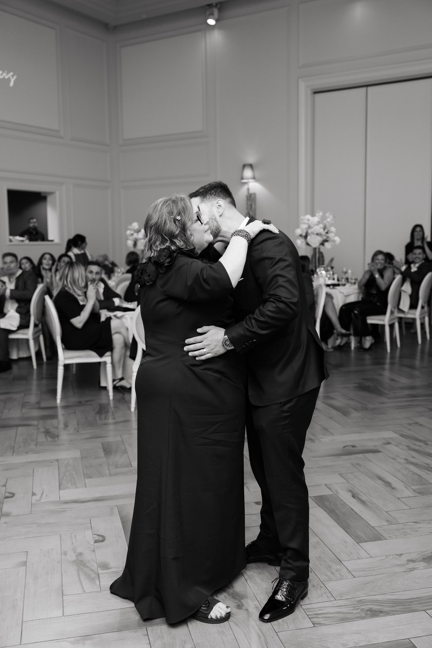 An intimate dance moment between wedding guests at an elegant reception venue.