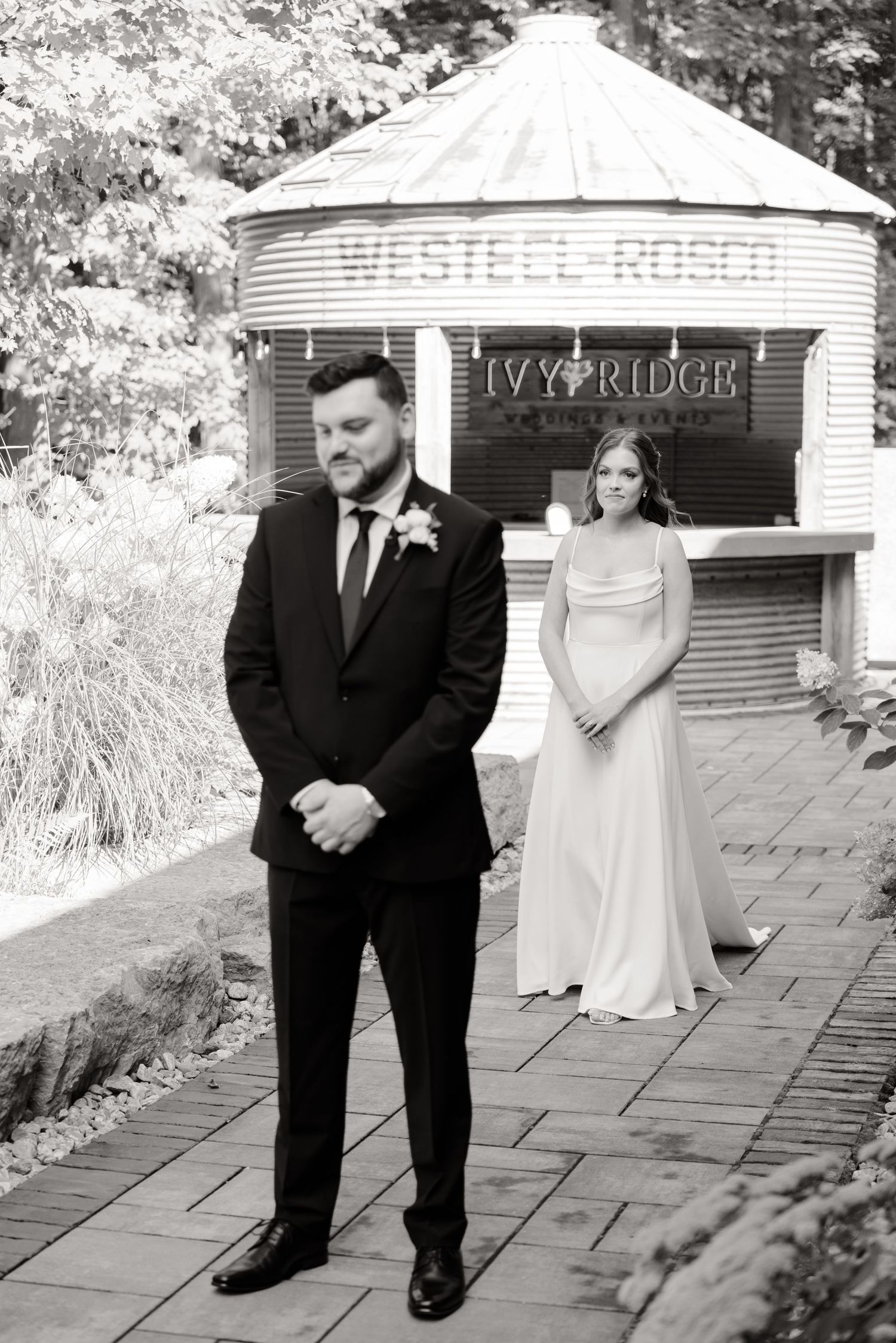 Black and white portrait of couple at vintage gazebo during first look moment.
