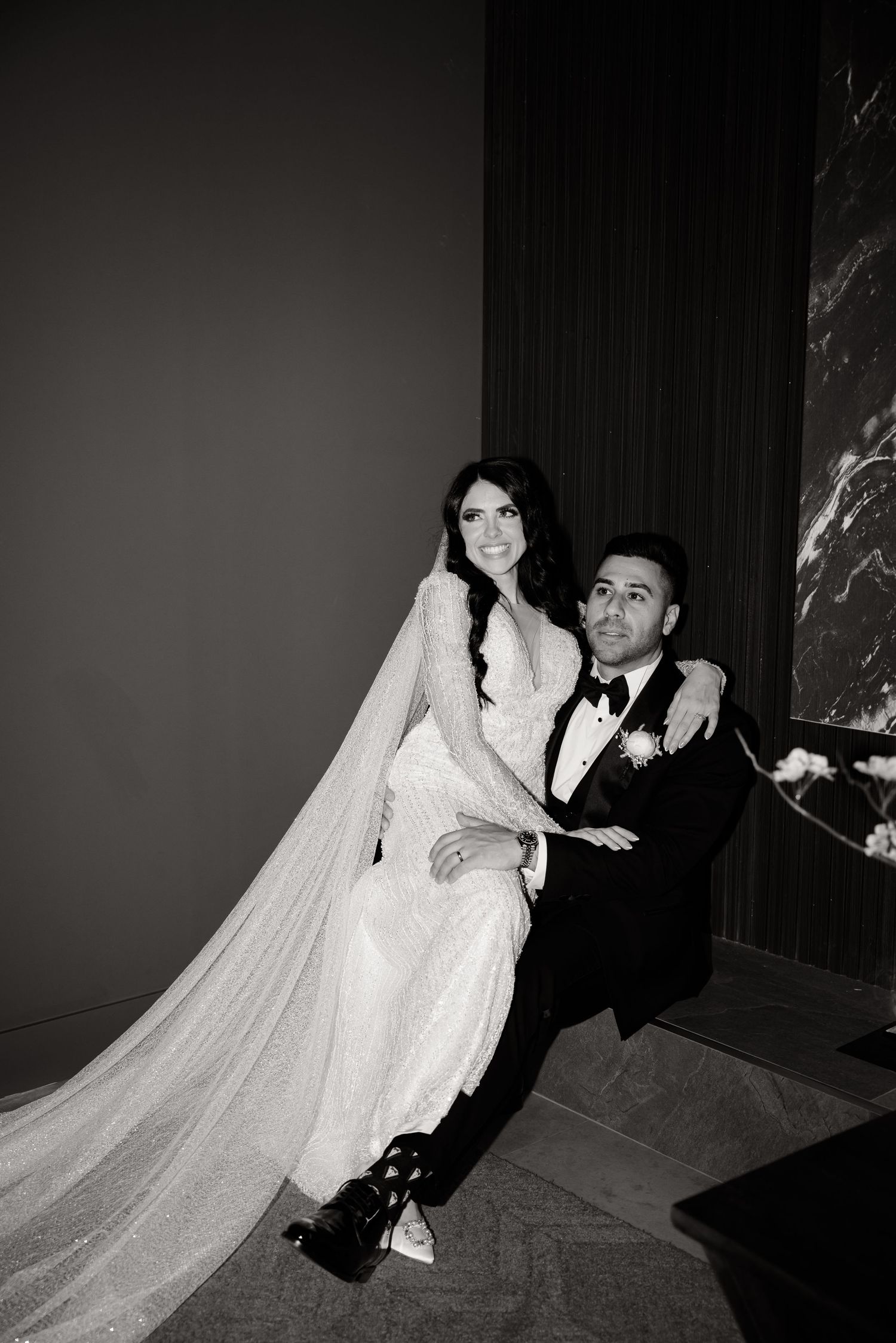 Artistic black and white wedding portrait in modern interior setting.