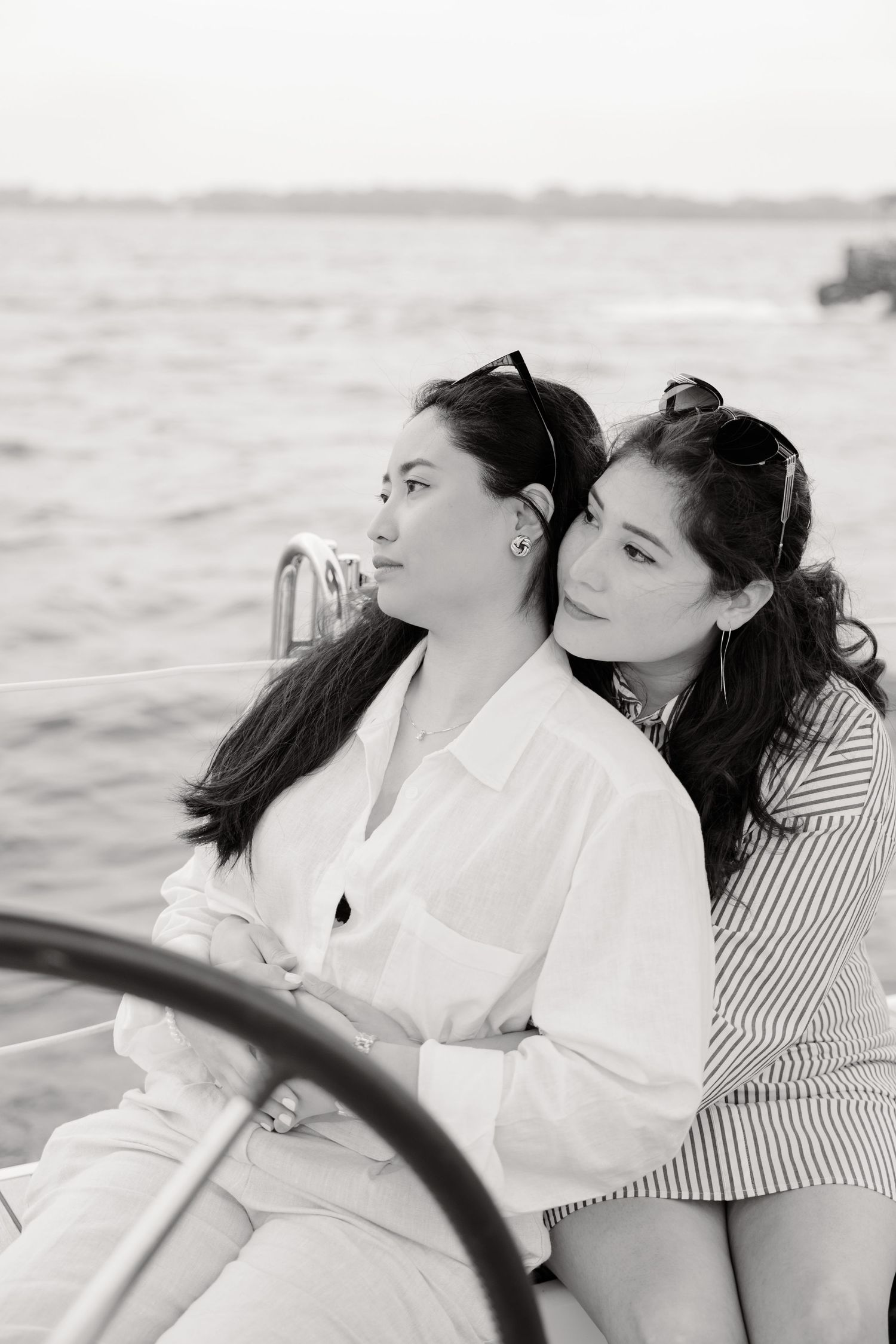A black and white photo of friends enjoying a peaceful boat ride together on the water.