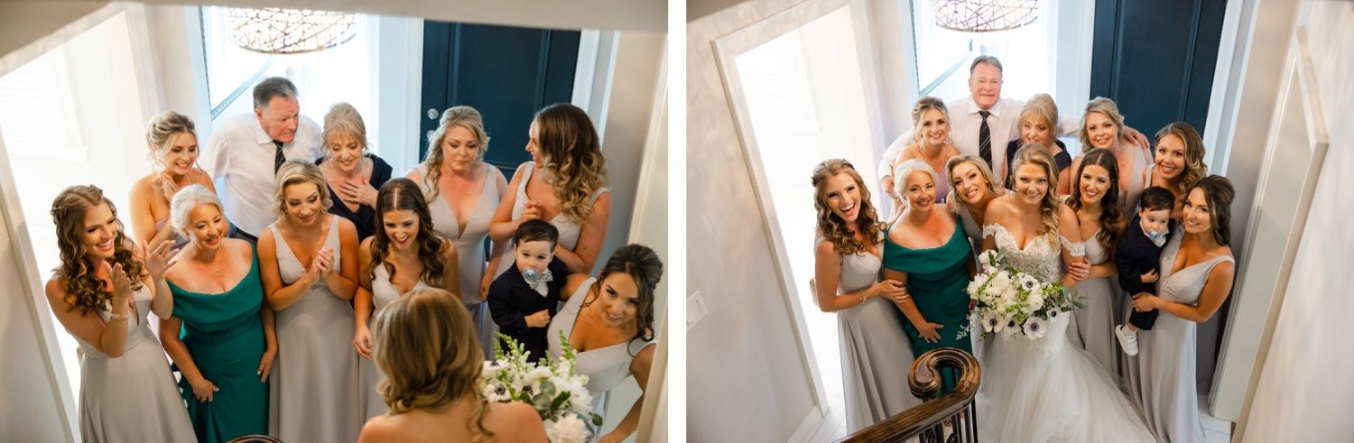 Large wedding party poses together in formal attire with bridesmaids in teal dresses.