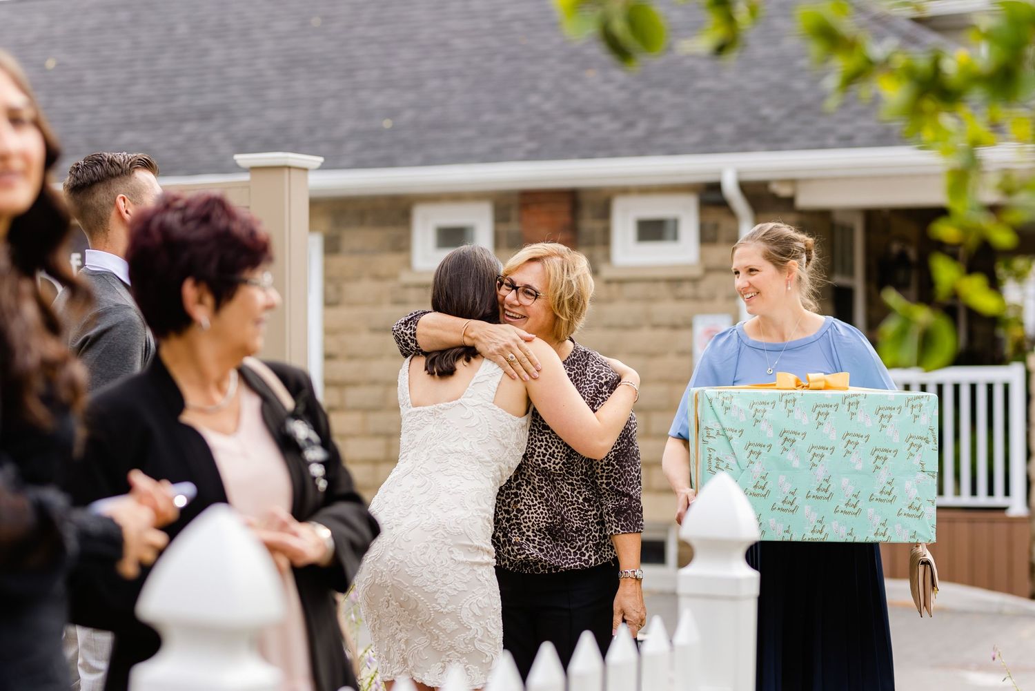 Group gathering on a deck during a celebration with someone holding a sign.