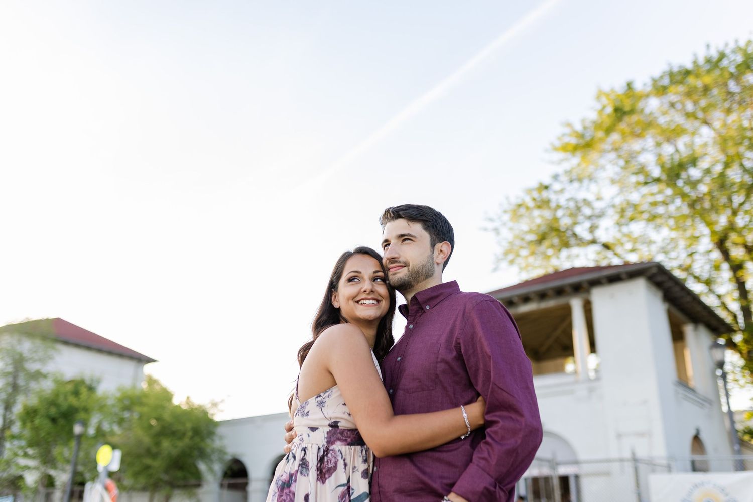 Sweet embrace captured during outdoor photoshoot near white building.