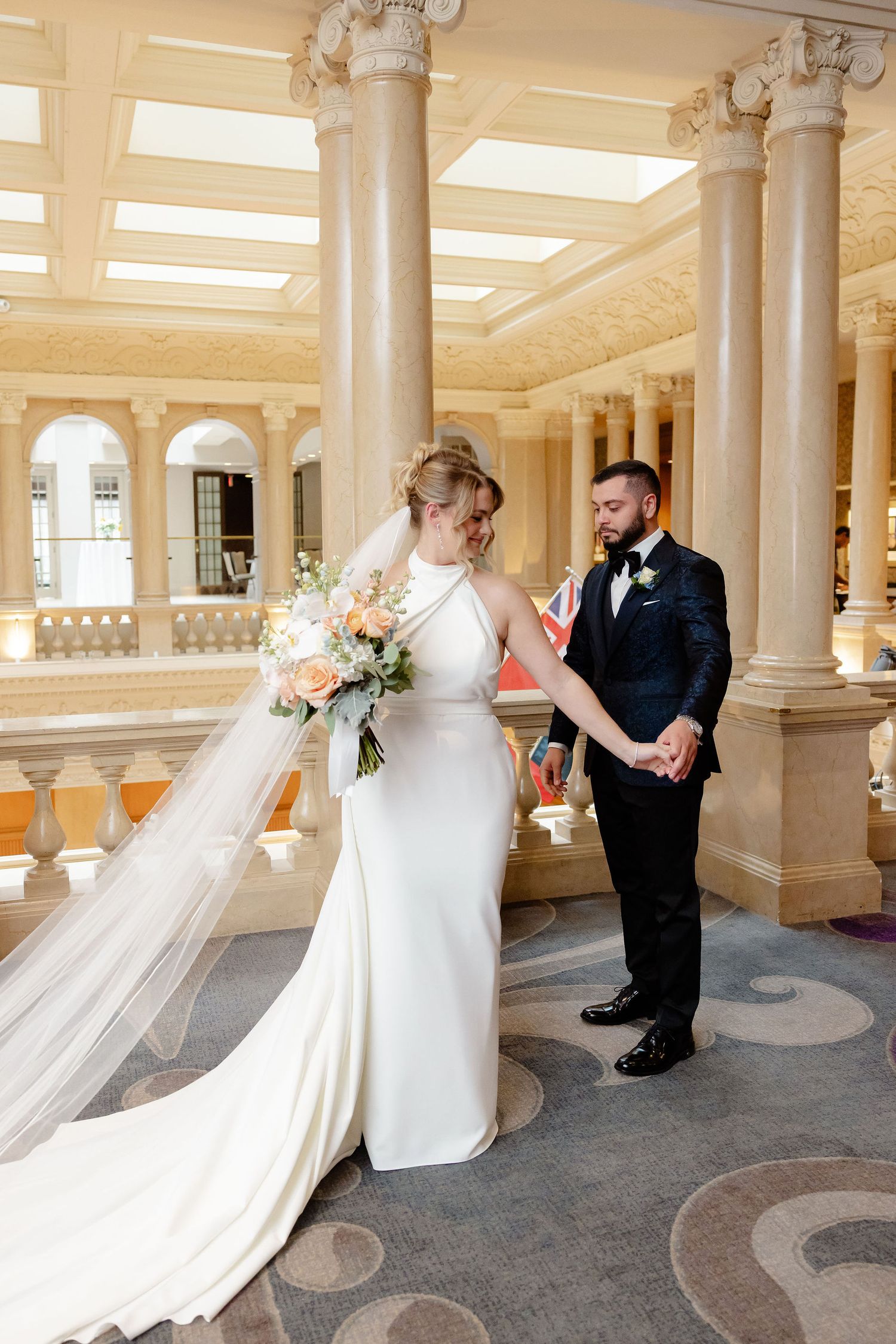 Sequence of wedding photos in an elegant pillared venue with dramatic lighting and flowing veil.