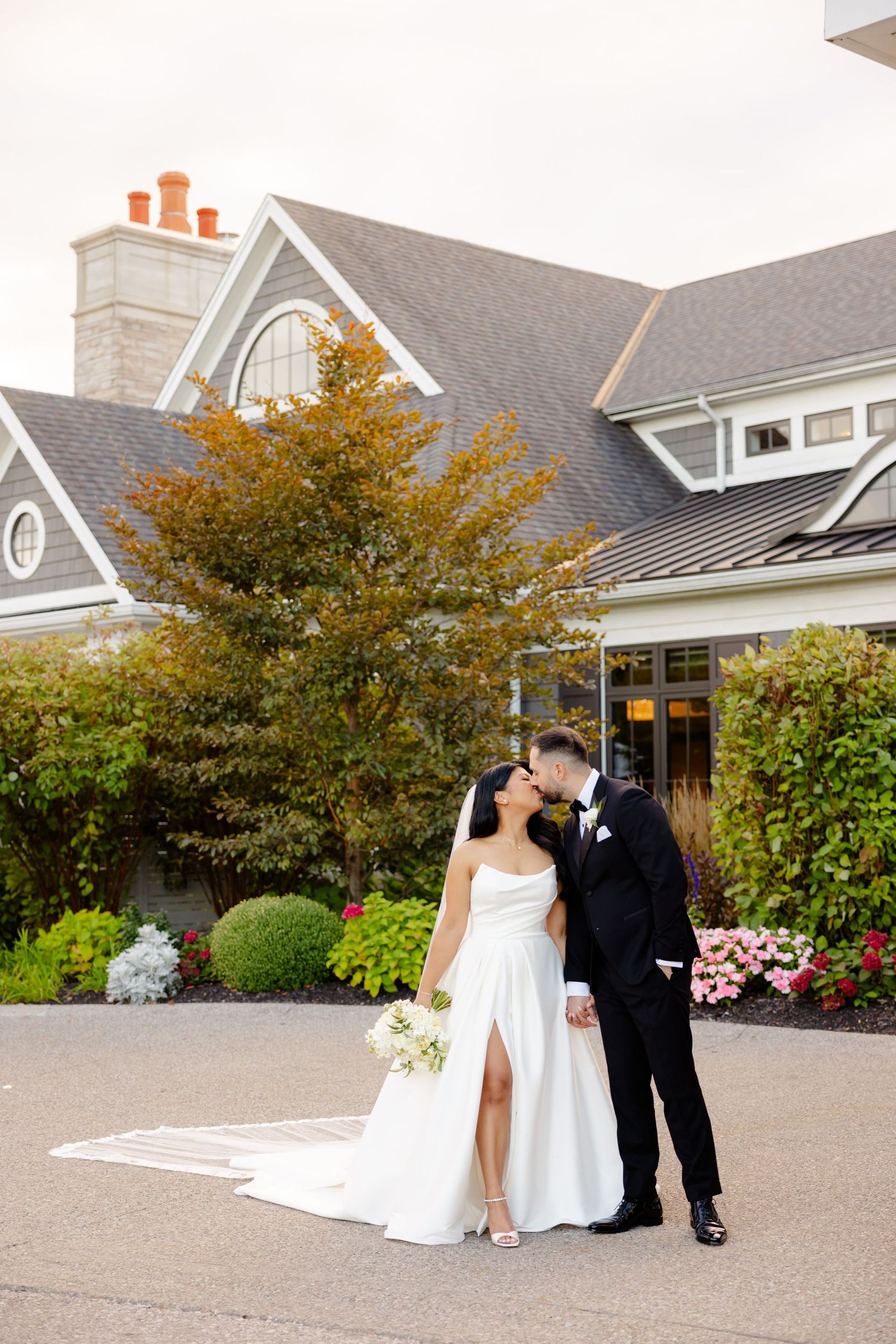 Newlyweds share an intimate moment outside their elegant wedding venue.