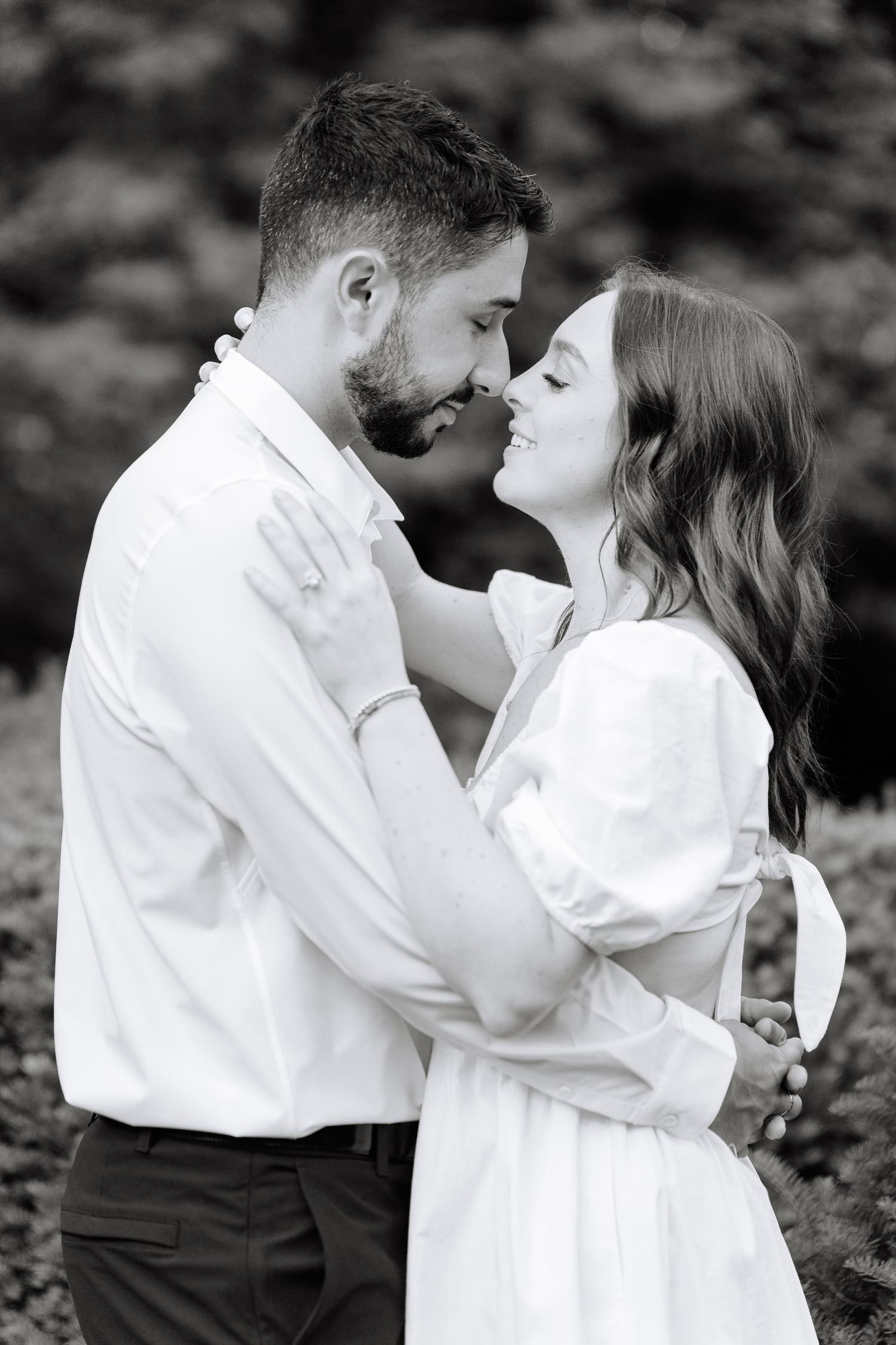 Black and white close-up of a couple sharing an intimate moment outdoors.