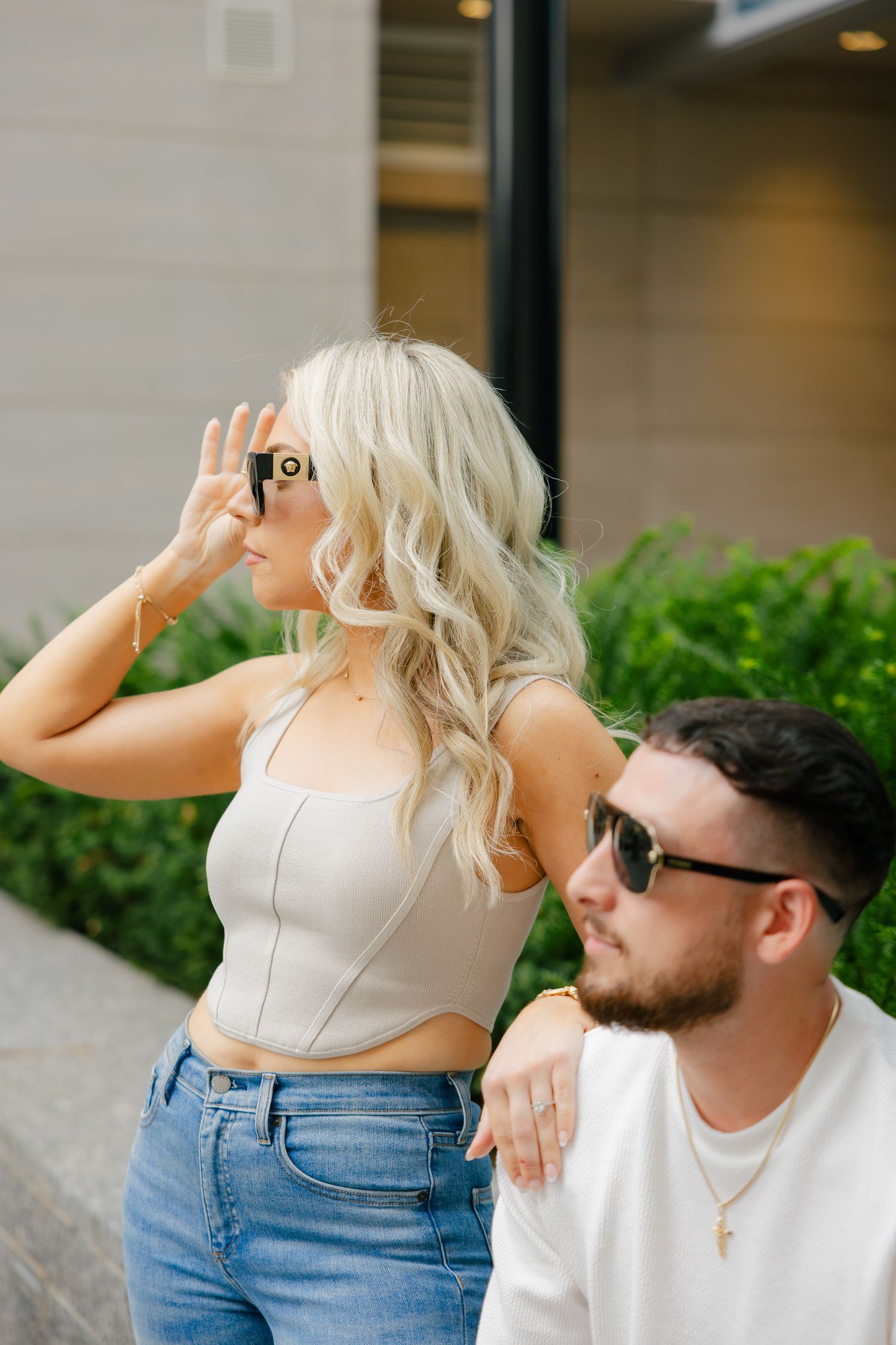 Lifestyle portrait of couple in complementary outfits near office building.