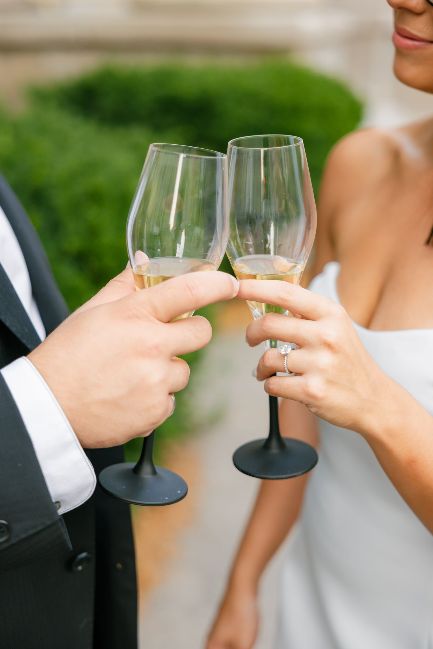 Close-up of hands clinking wine glasses during a formal celebration.