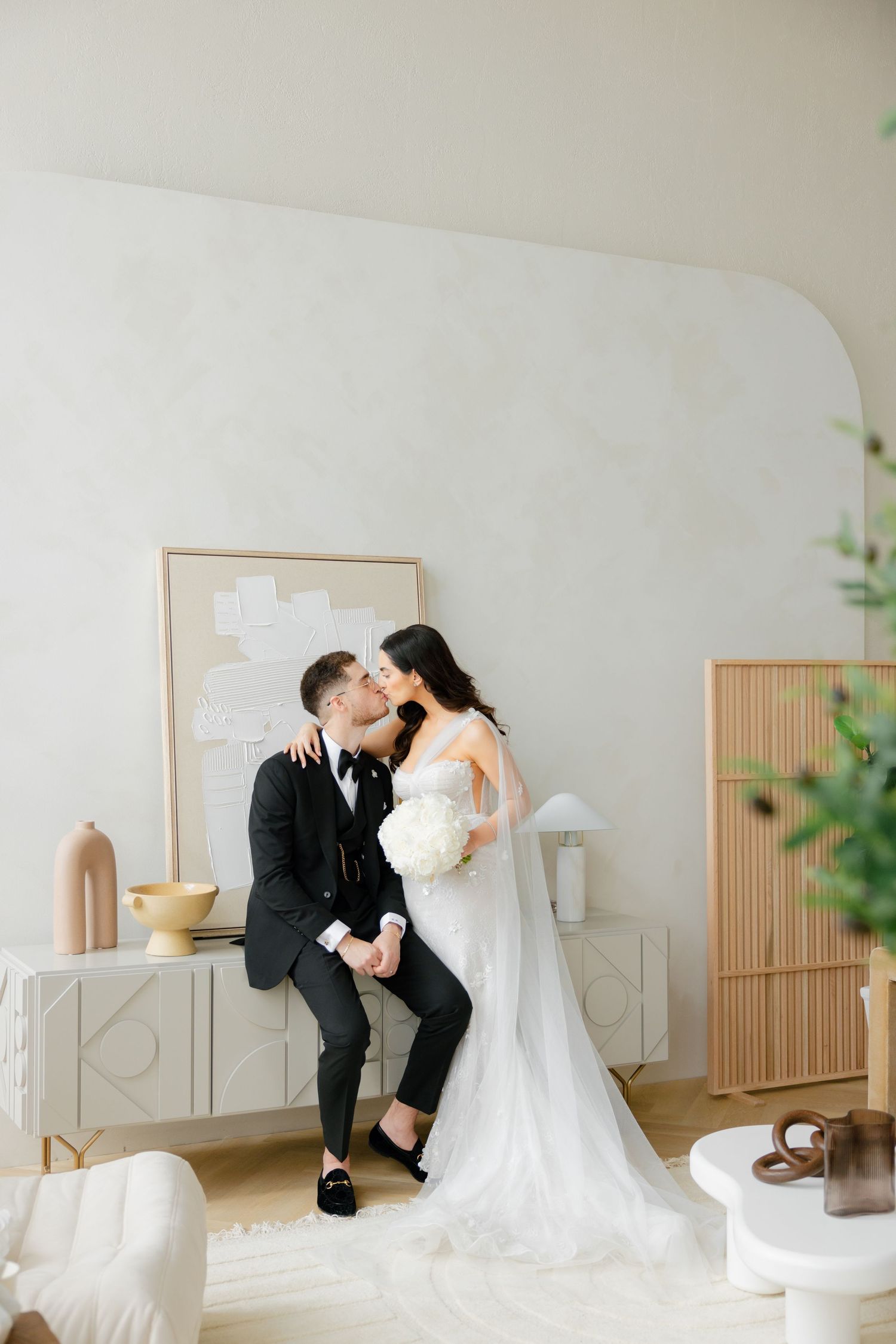 A minimalist wedding scene in white room with modern decor and furniture.