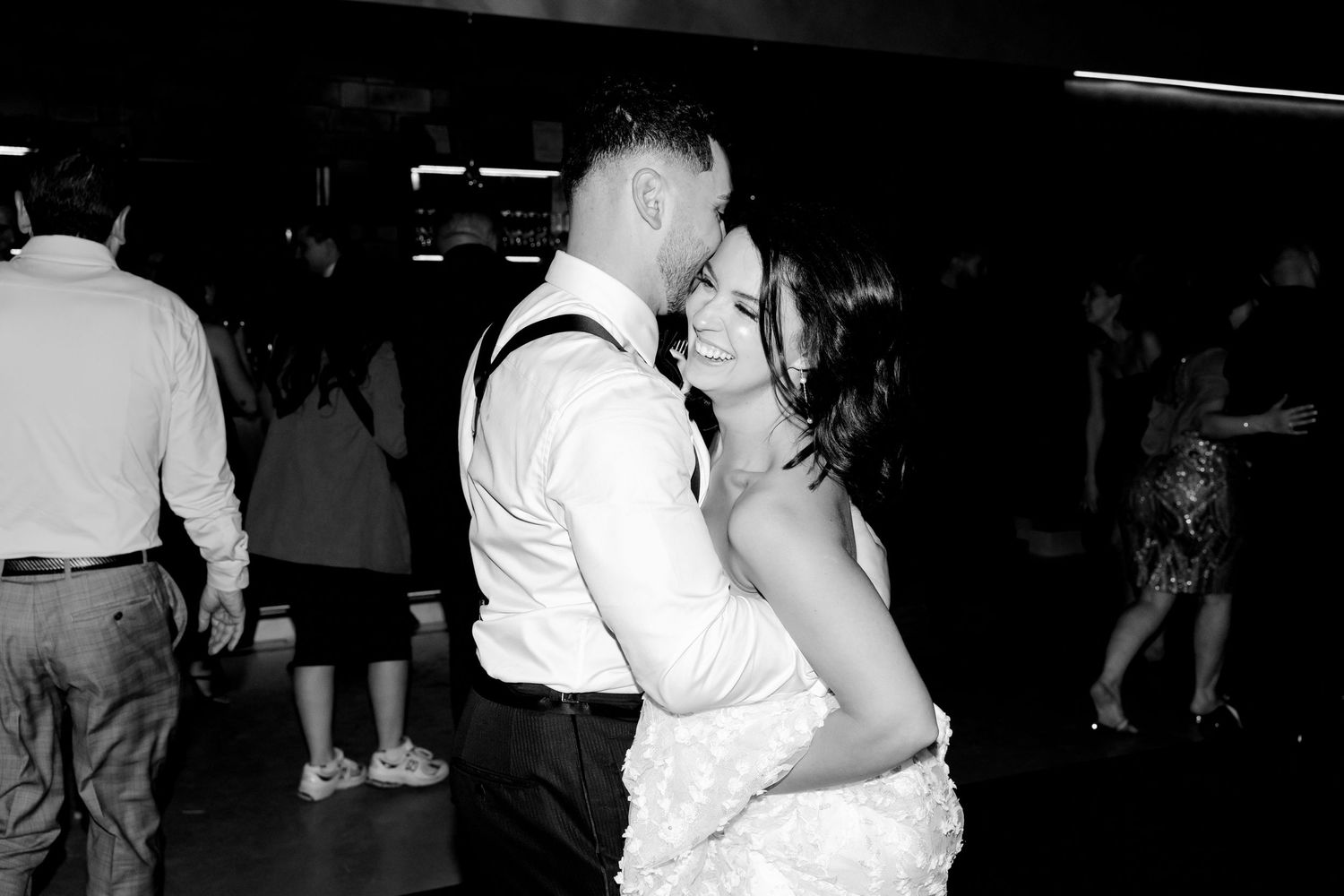 Couple sharing intimate dance moment at wedding reception in black and white.