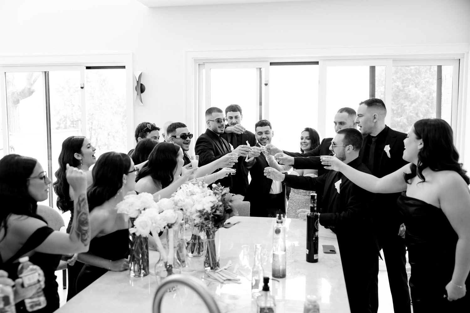 Wedding party toasting at a reception table with celebratory drinks.