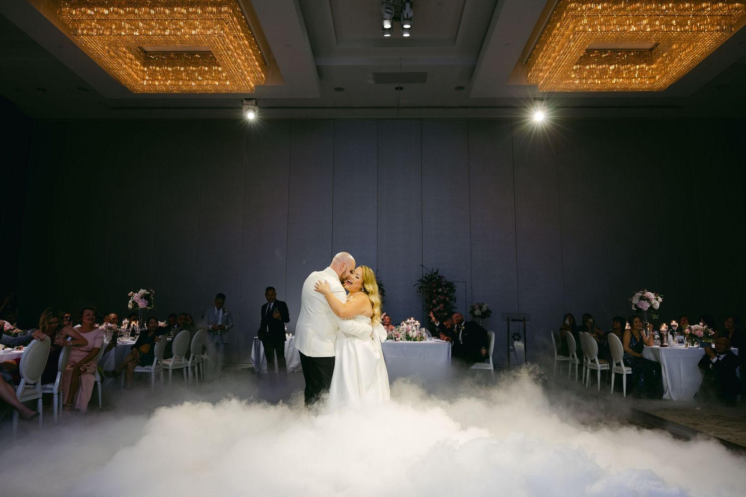 Newlyweds share an intimate moment during their fog-filled first dance.