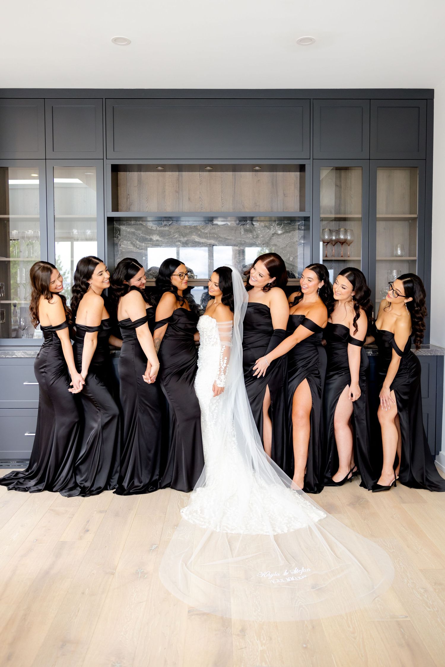 Candid moment of bridal party laughing together in front of modern kitchen cabinetry.