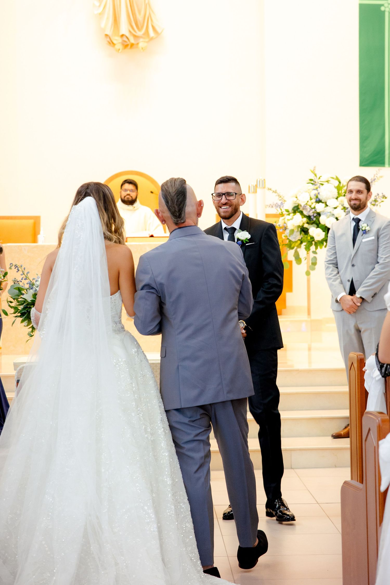 A wedding ceremony taking place at the altar of a modern church with elegant decor.