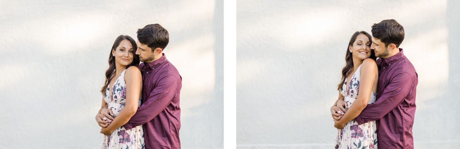 Couple shares a tender moment against cloudy sky background in complementary burgundy and floral attire.