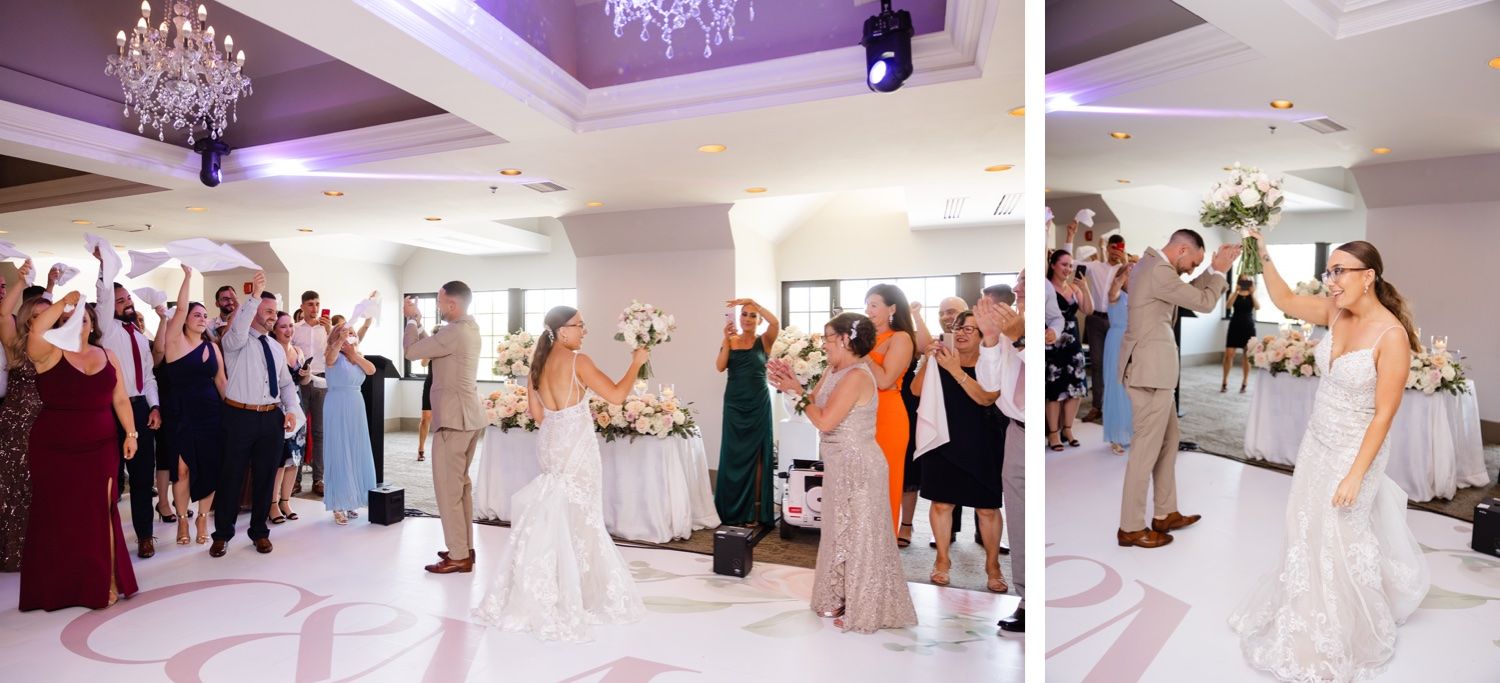 Wedding reception celebration with guests cheering under crystal chandeliers and purple lighting.