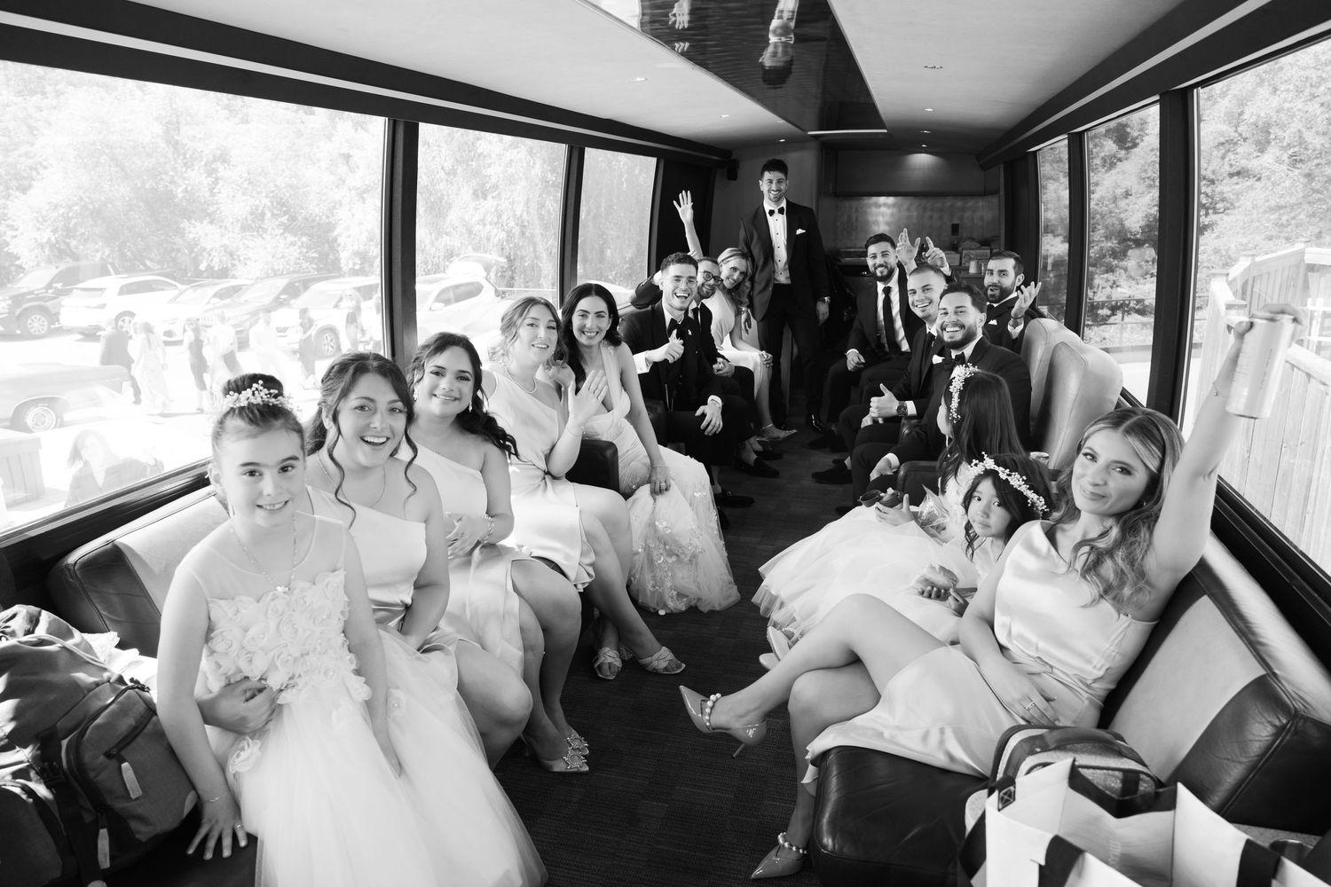 Wedding party celebrating together inside a party bus with joyful expressions.