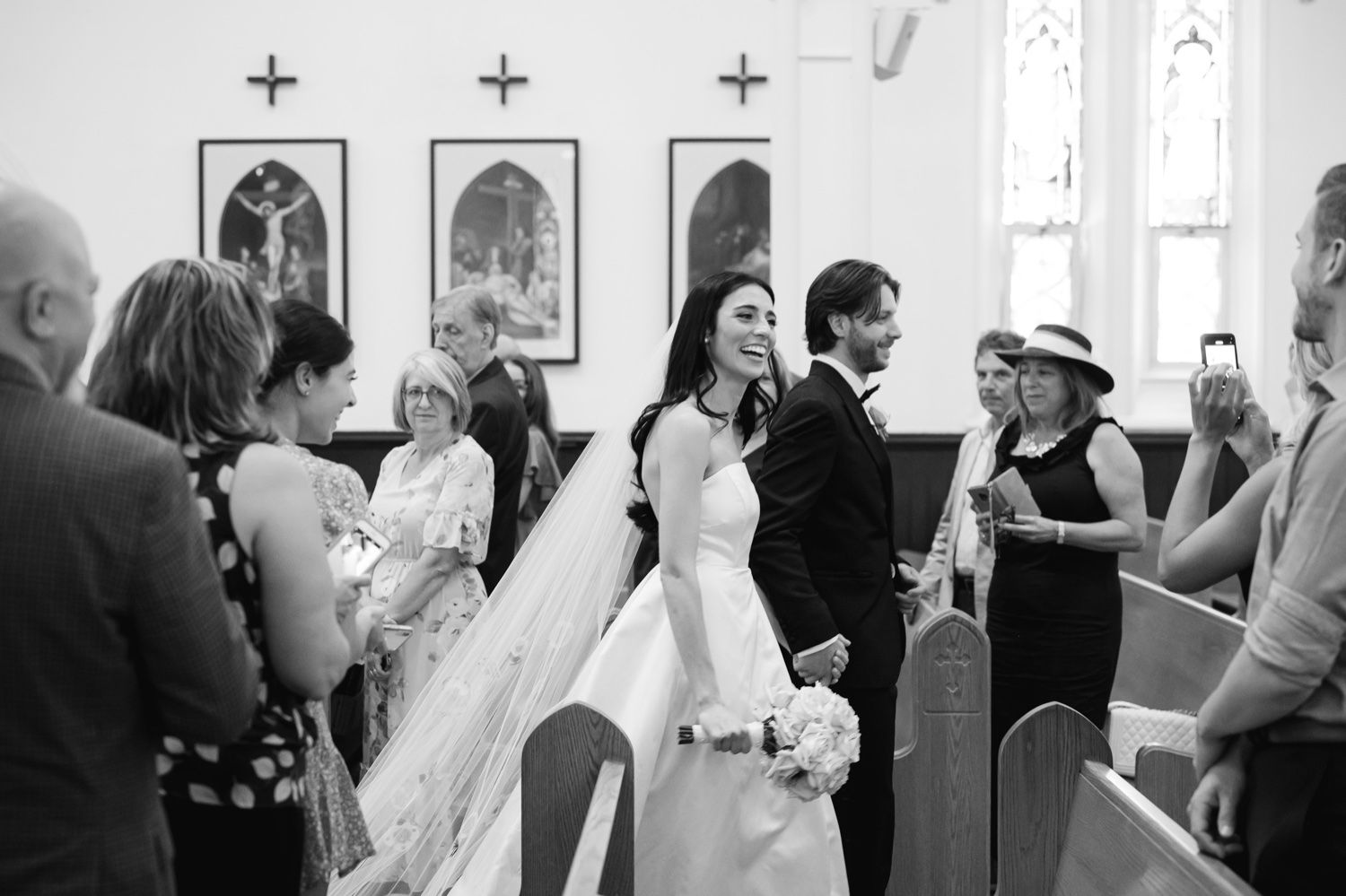 A wedding ceremony takes place in a church with guests seated in pews.