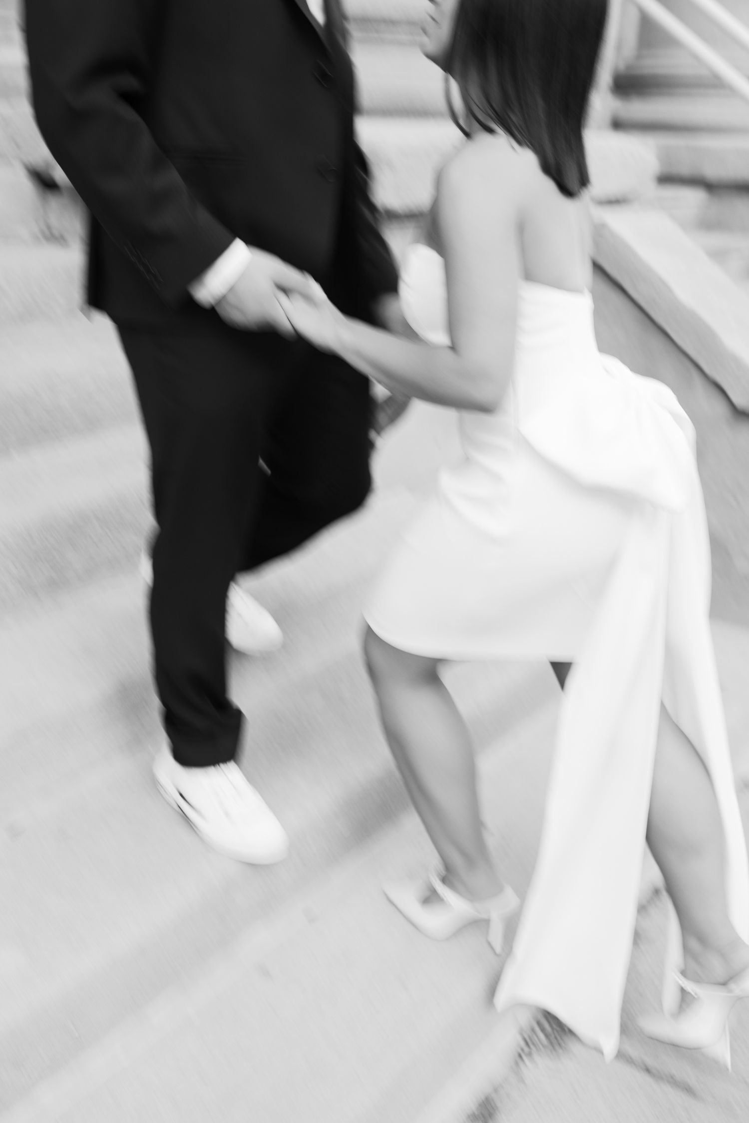 Artistic motion blur capture of couple in formal wear dancing on stone steps.