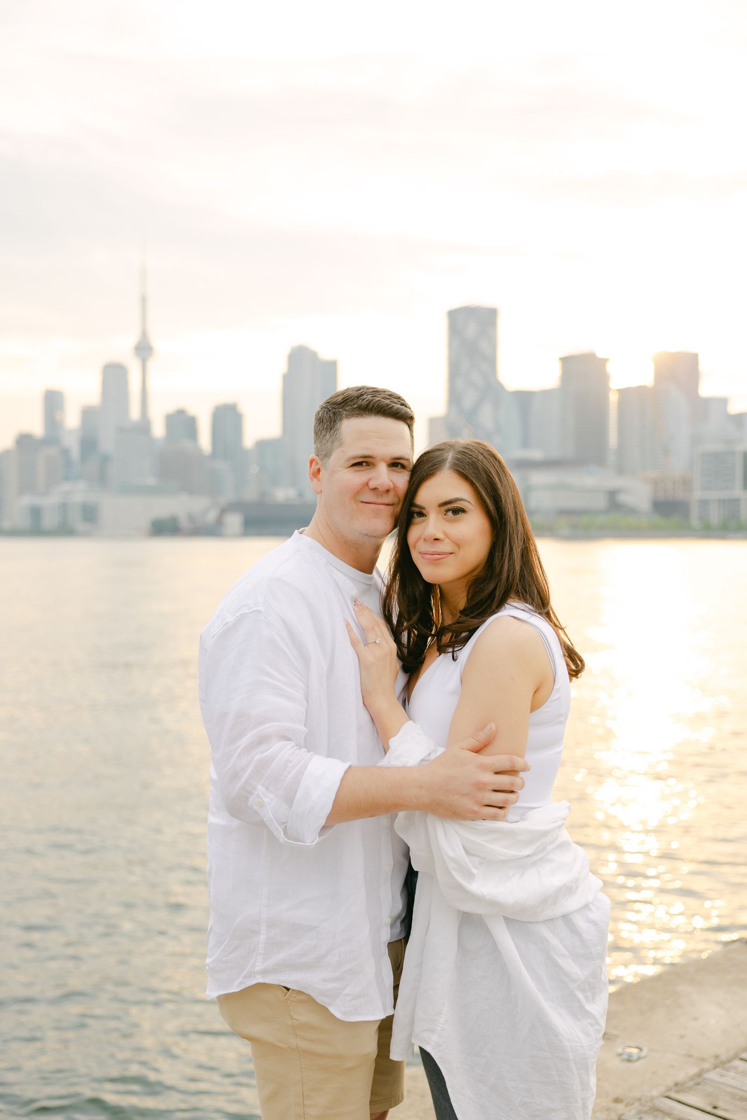 A romantic golden hour portrait of a couple embracing by the Toronto waterfront.