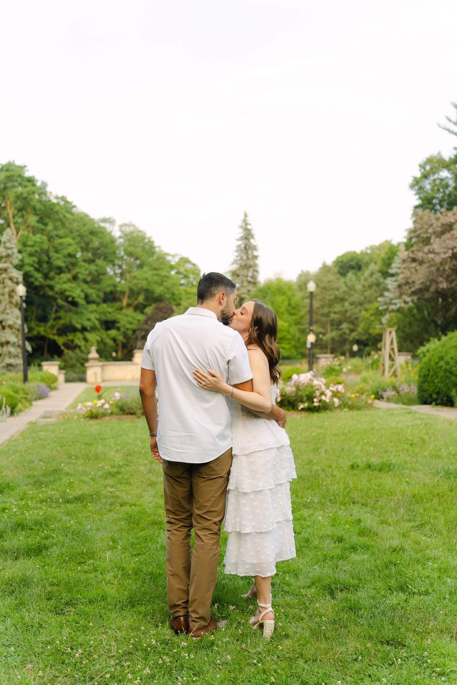 A romantic moment captured between a couple in a serene garden landscape.