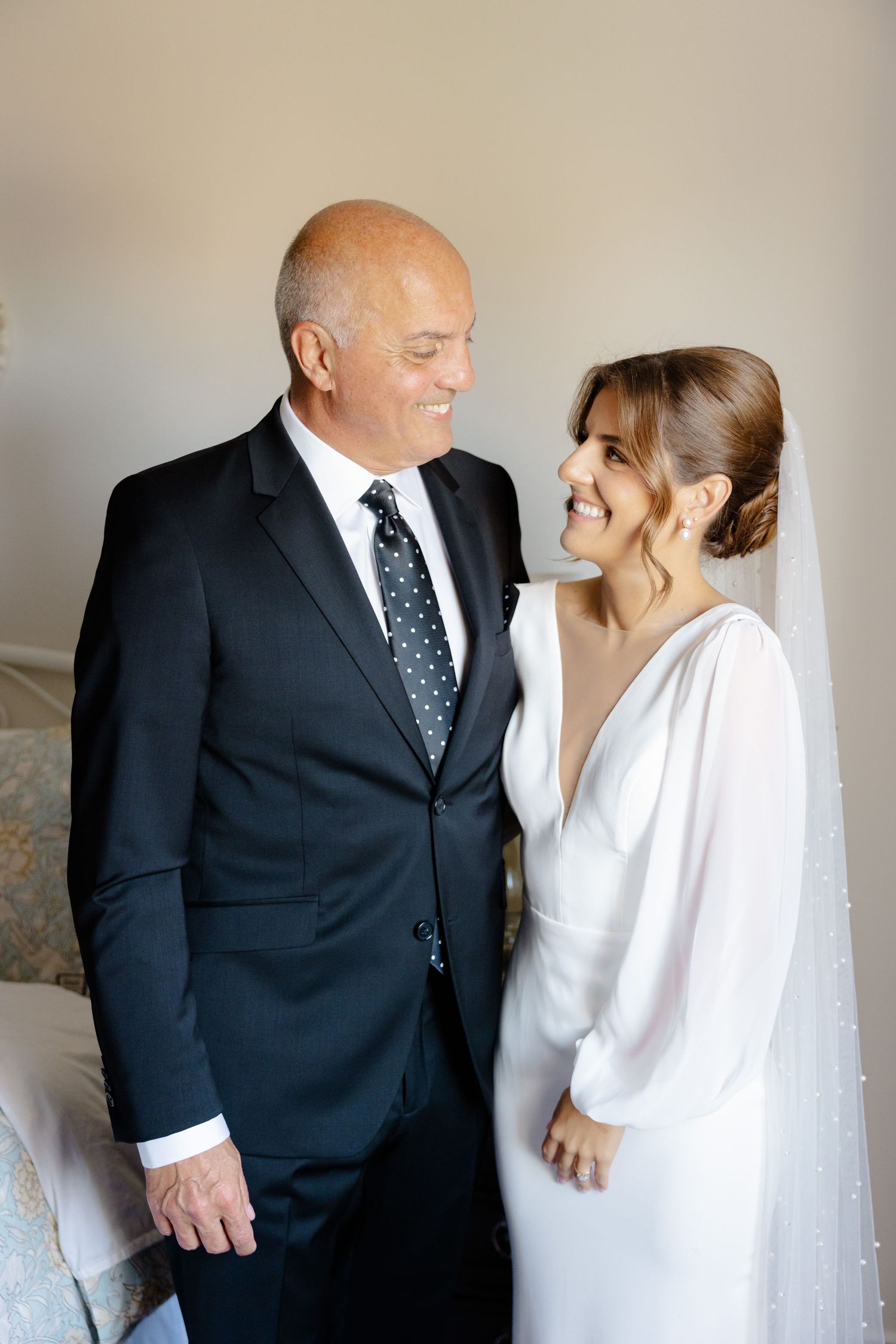 Candid moment captured between pair in formal wedding attire with natural lighting.