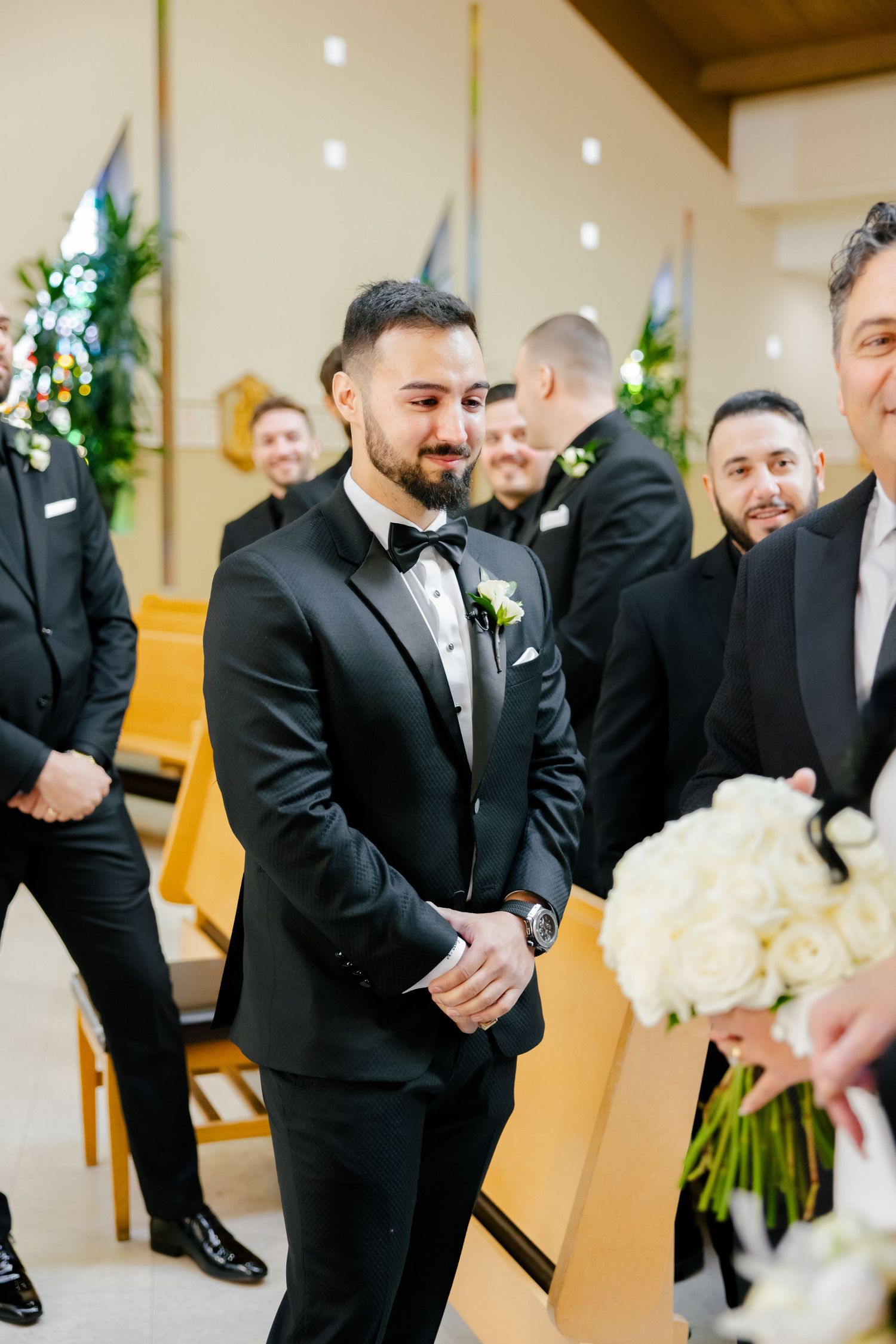 Wedding party members in black tuxedos gather before the ceremony.
