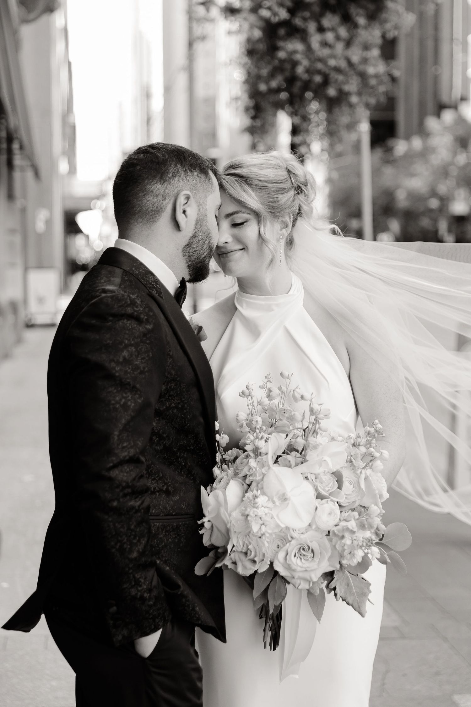Black and white wedding photos showing intimate moments between newlyweds with flowing veil.