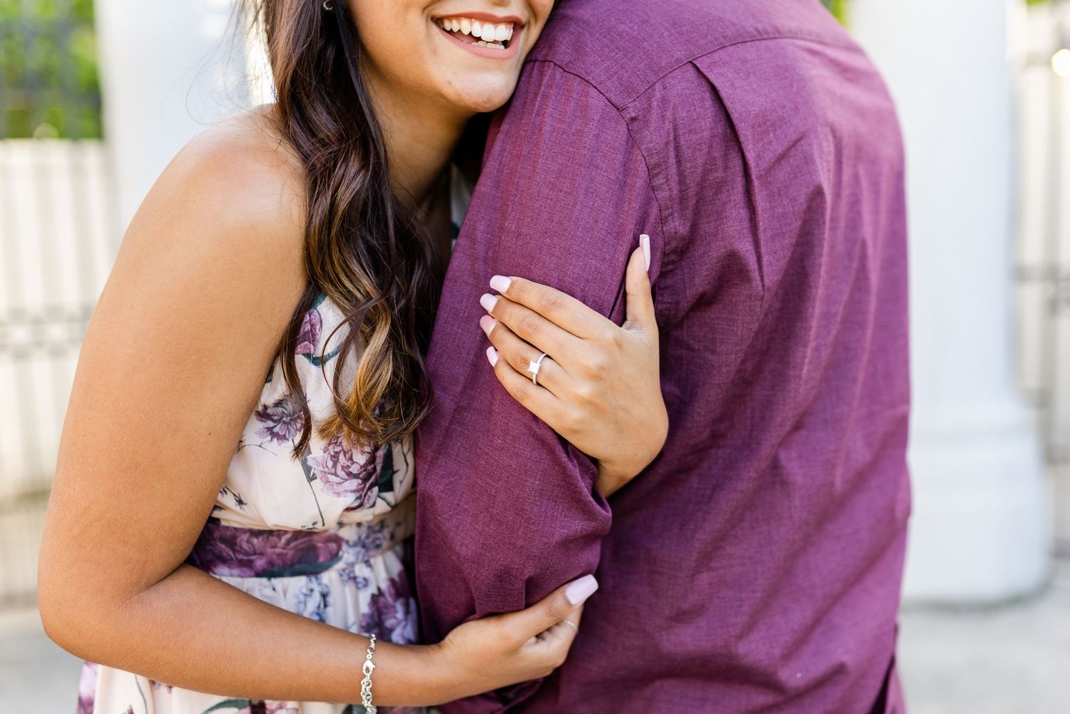 Close-up of couple embracing and smiling during outdoor photoshoot.