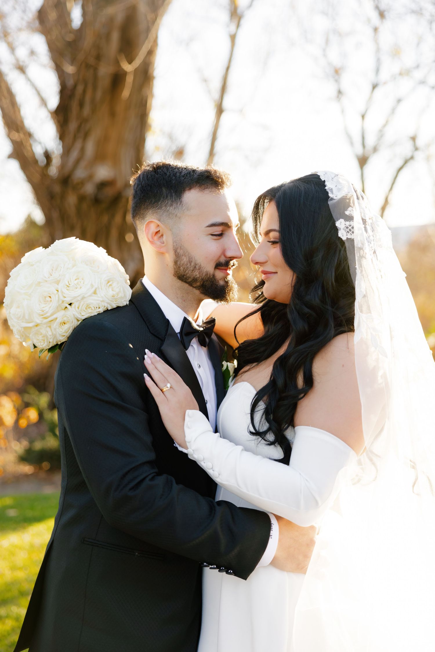 Intimate wedding portrait of couple sharing romantic moment in golden autumn light.