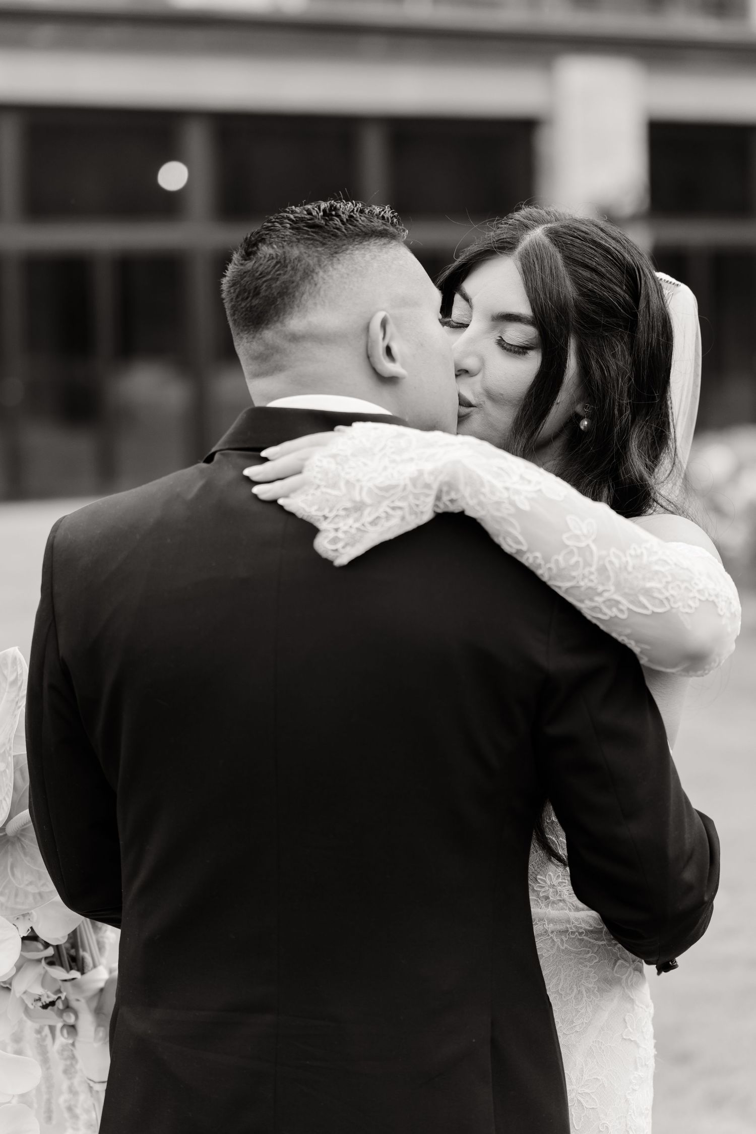 A series of four black and white romantic wedding photos showing tender moments between a bride and groom.