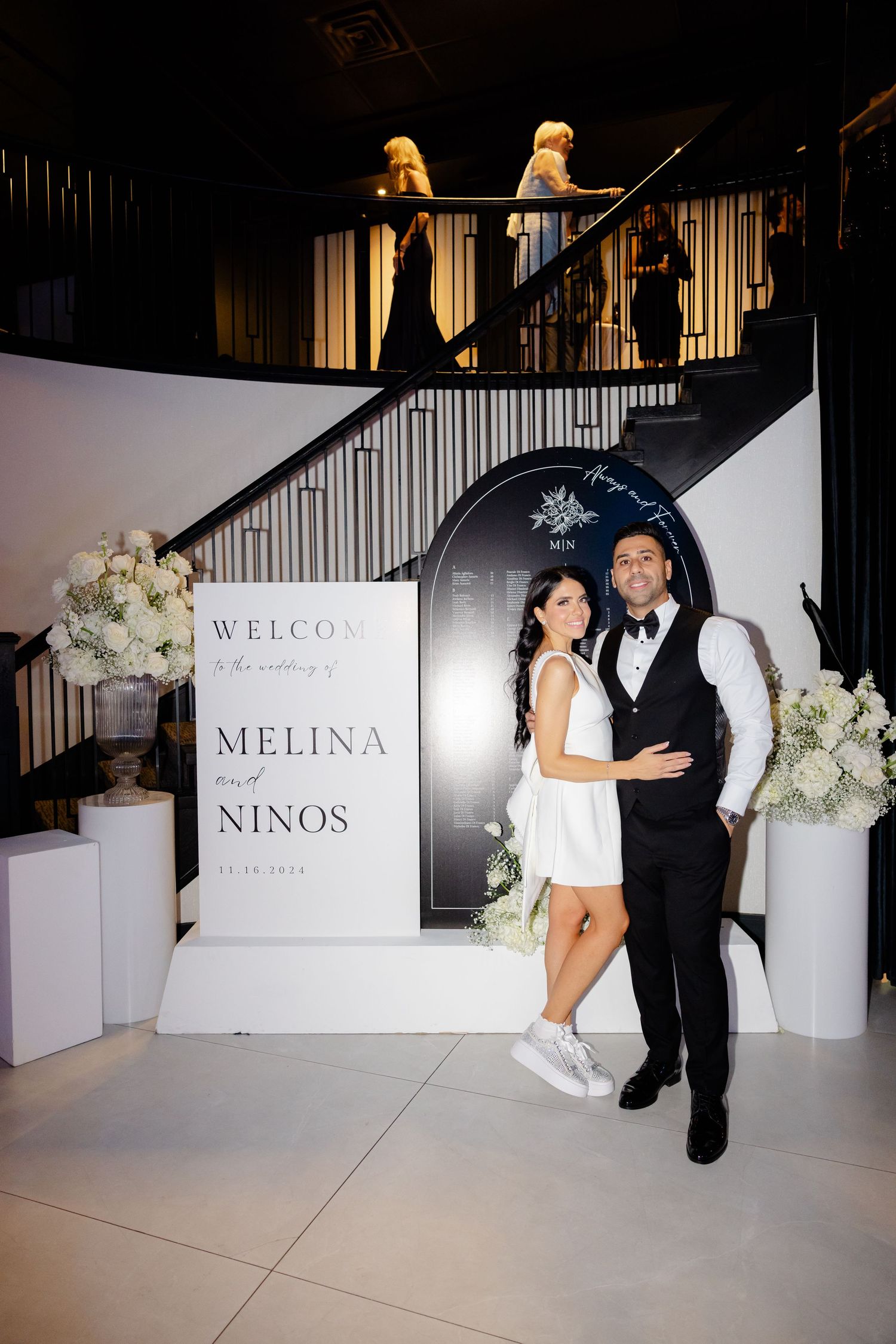 Wedding welcome sign display with elegant arch and floral decorations at venue entrance.