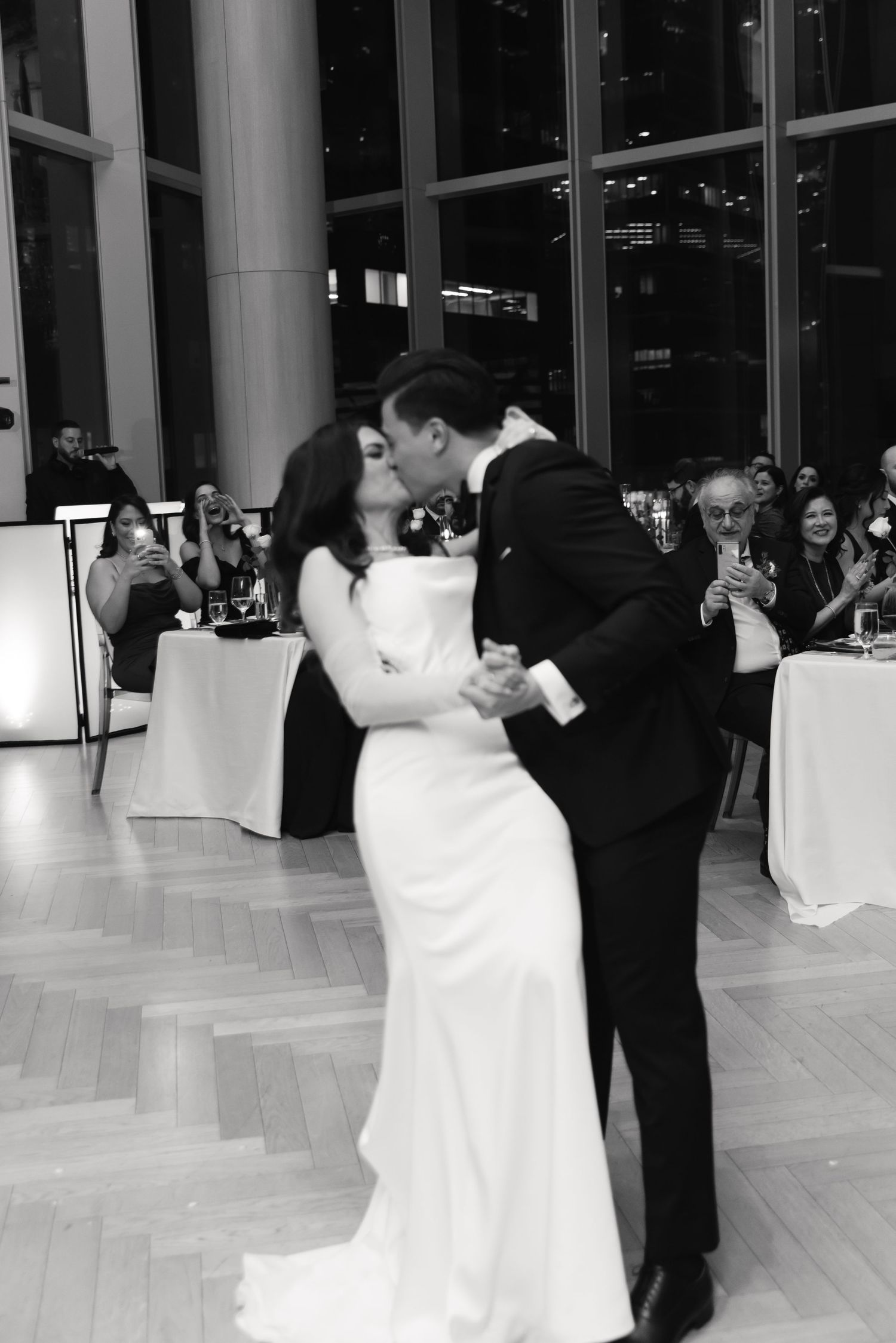 Black and white photo of newlyweds sharing a romantic dance moment at their reception.